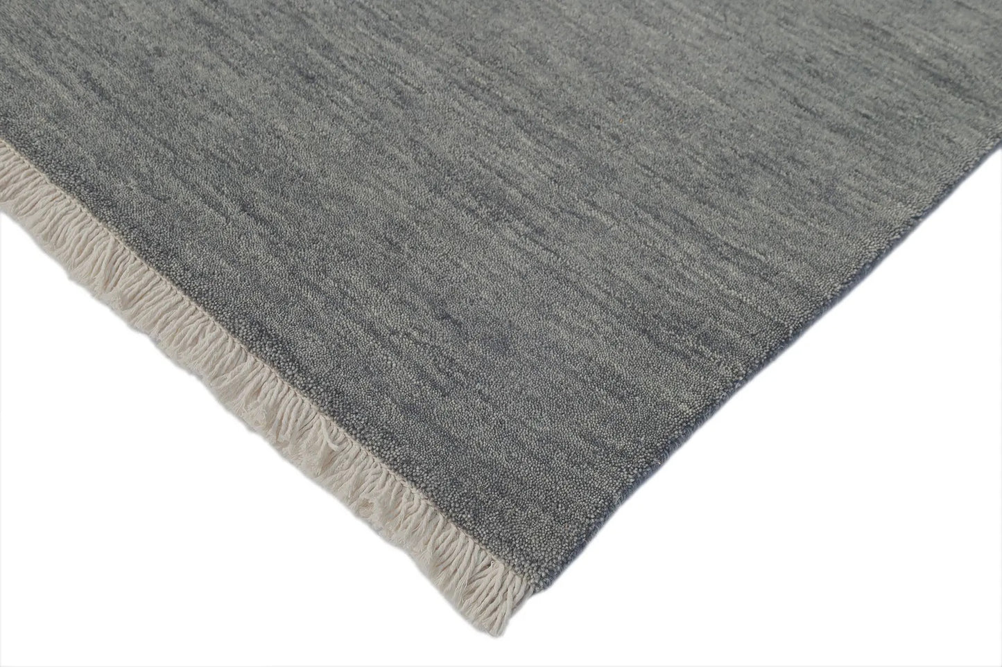 Lori Smoke is a luxurious hand loomed floor rug made of 100% wool. The wool material creates a soft texture and a smooth pile height of 16-18mm. Colour dark smokey Grey with cream tassels. Sizes 160 X 230, 200 X 290, 240 X 340 and 300 X 400. Corner.