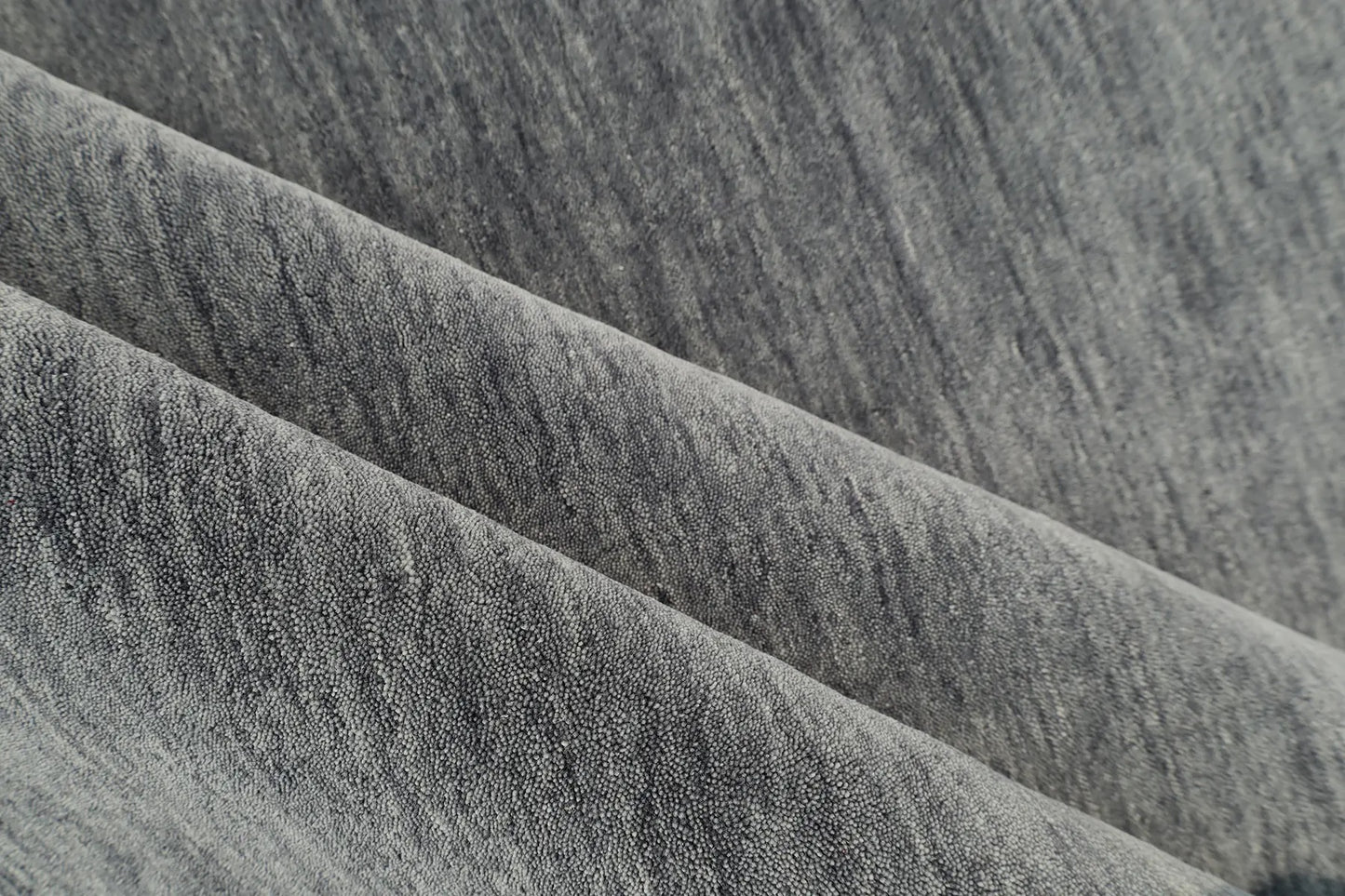 Lori Smoke is a luxurious hand loomed floor rug made of 100% wool. The wool material creates a soft texture and a smooth pile height of 16-18mm. Colour dark smokey Grey with cream tassels. Sizes 160 X 230, 200 X 290, 240 X 340 and 300 X 400. Roll.