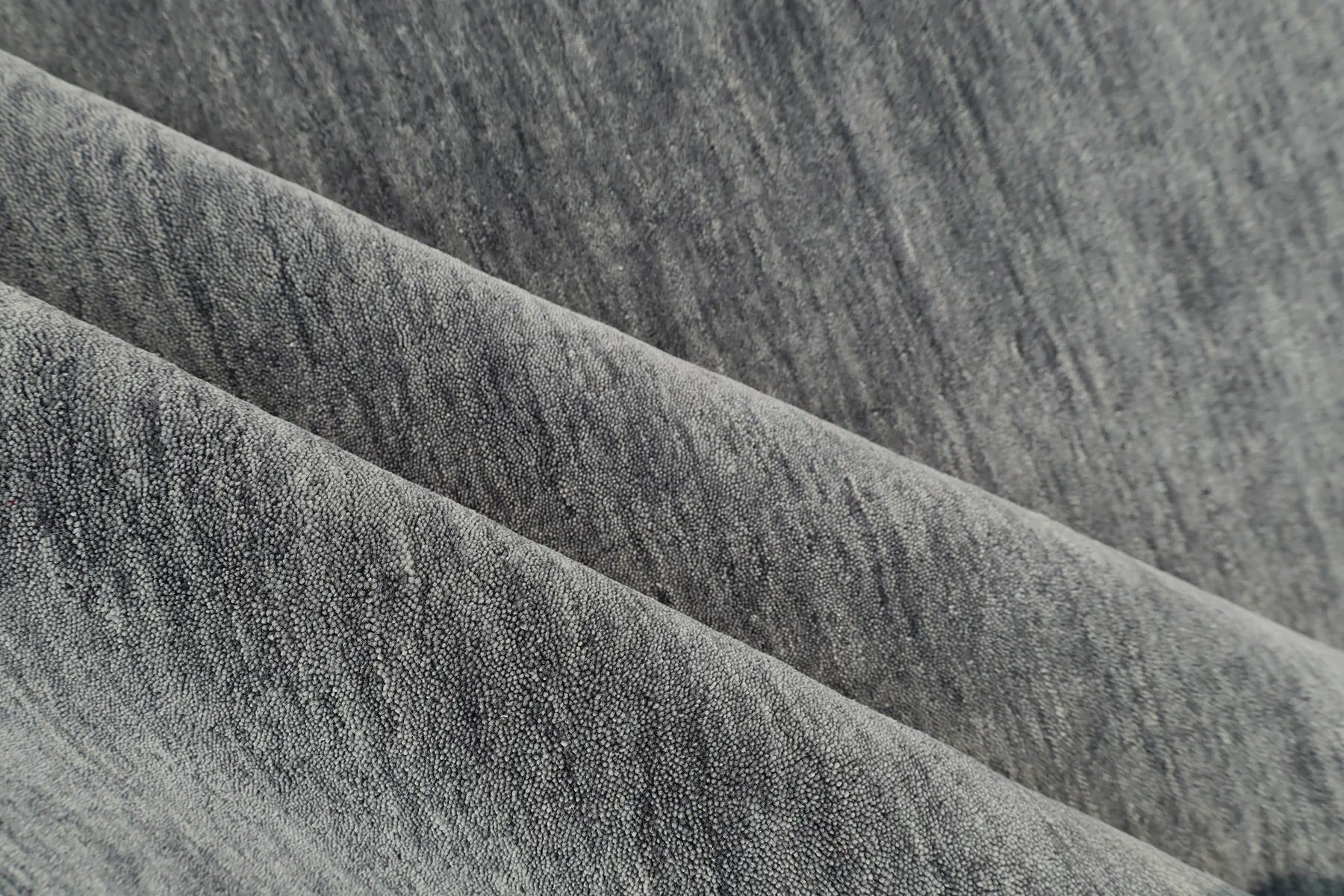 Lori Smoke is a luxurious hand loomed floor rug made of 100% wool. The wool material creates a soft texture and a smooth pile height of 16-18mm. Colour dark smokey Grey with cream tassels. Sizes 160 X 230, 200 X 290, 240 X 340 and 300 X 400. Roll.