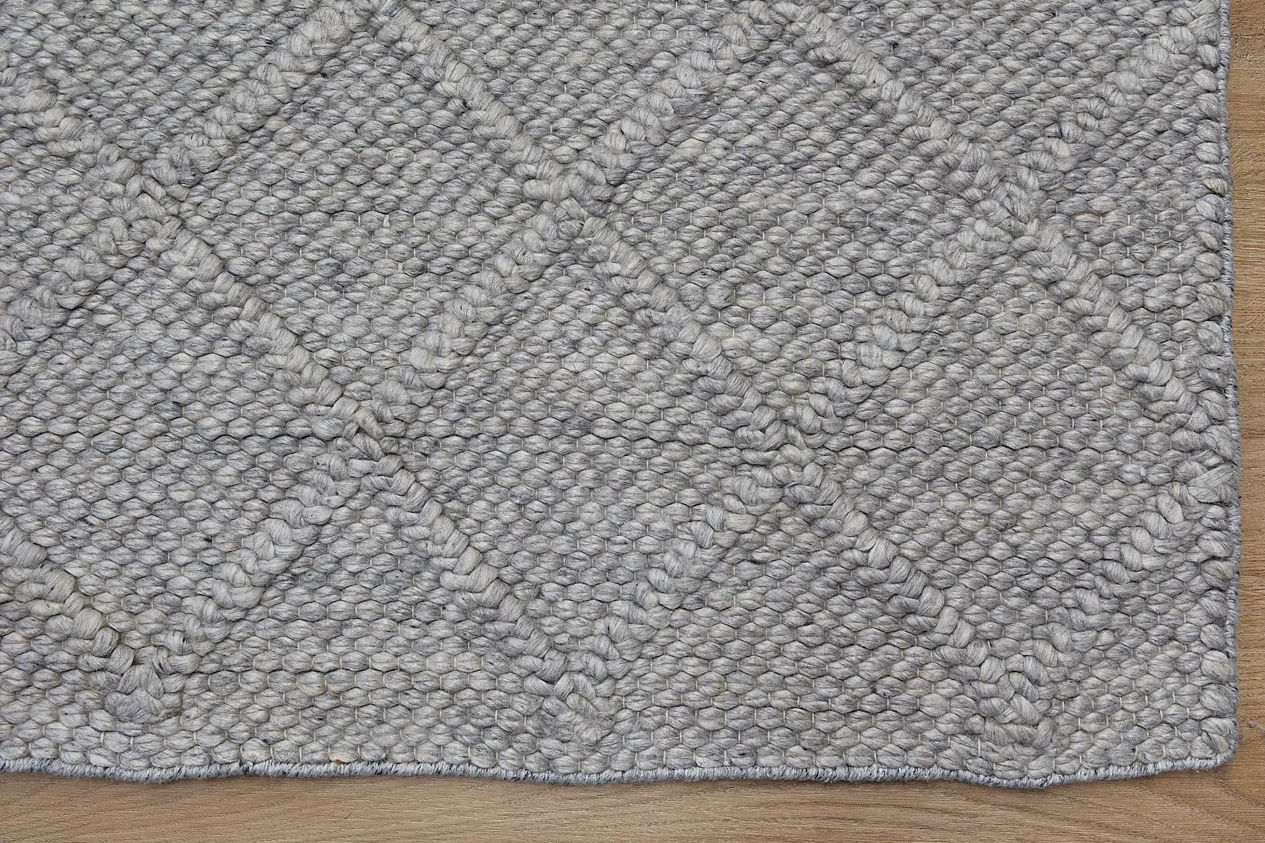 Lounge Aluminium is a luxurious wool and bamboo silk rug, featuring a modern Scandinavian Diamond Pattern design and textured hand loomed pile. With pile height of 16-18mm. Colour Aluminium Grey. Sizes 160 X 230, 200 X 290 and 240 X 340. Corner.