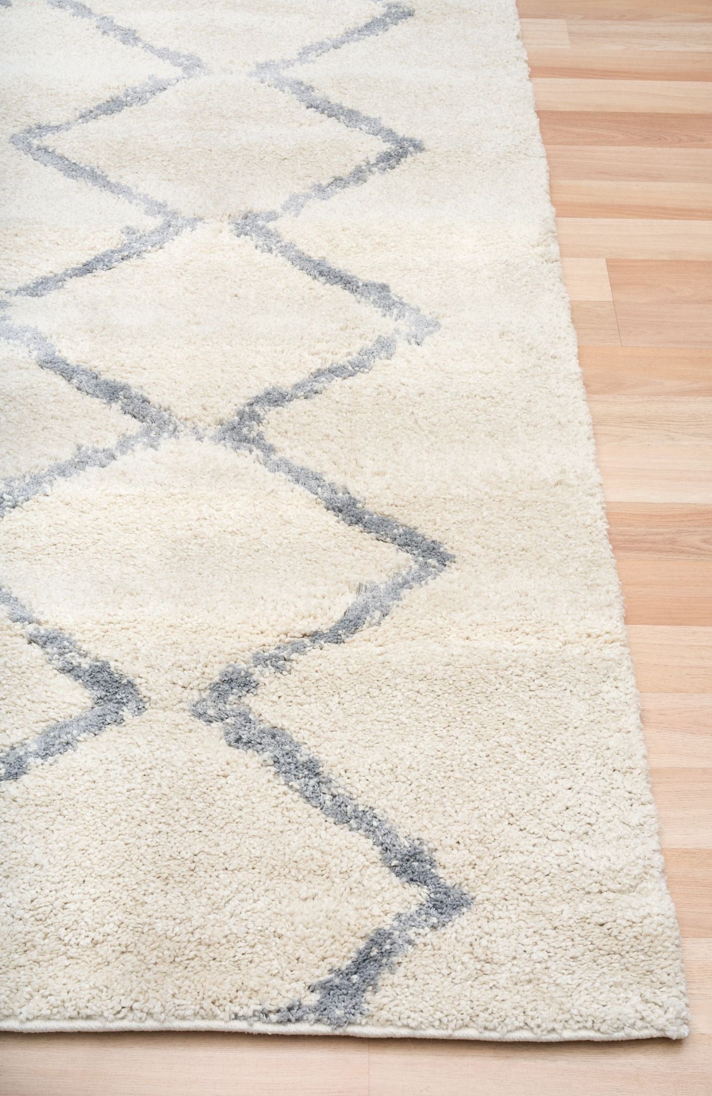 Luana Classic Ivory Grey is a machine made polypropylene rug.  It features a shaggy pile with a moroccan boho inspired design. Colours Ivory with a grey diamond pattern. Sizes 160 X 230, 200 X 290, 240 X 320 and 300 X 390. Corner.