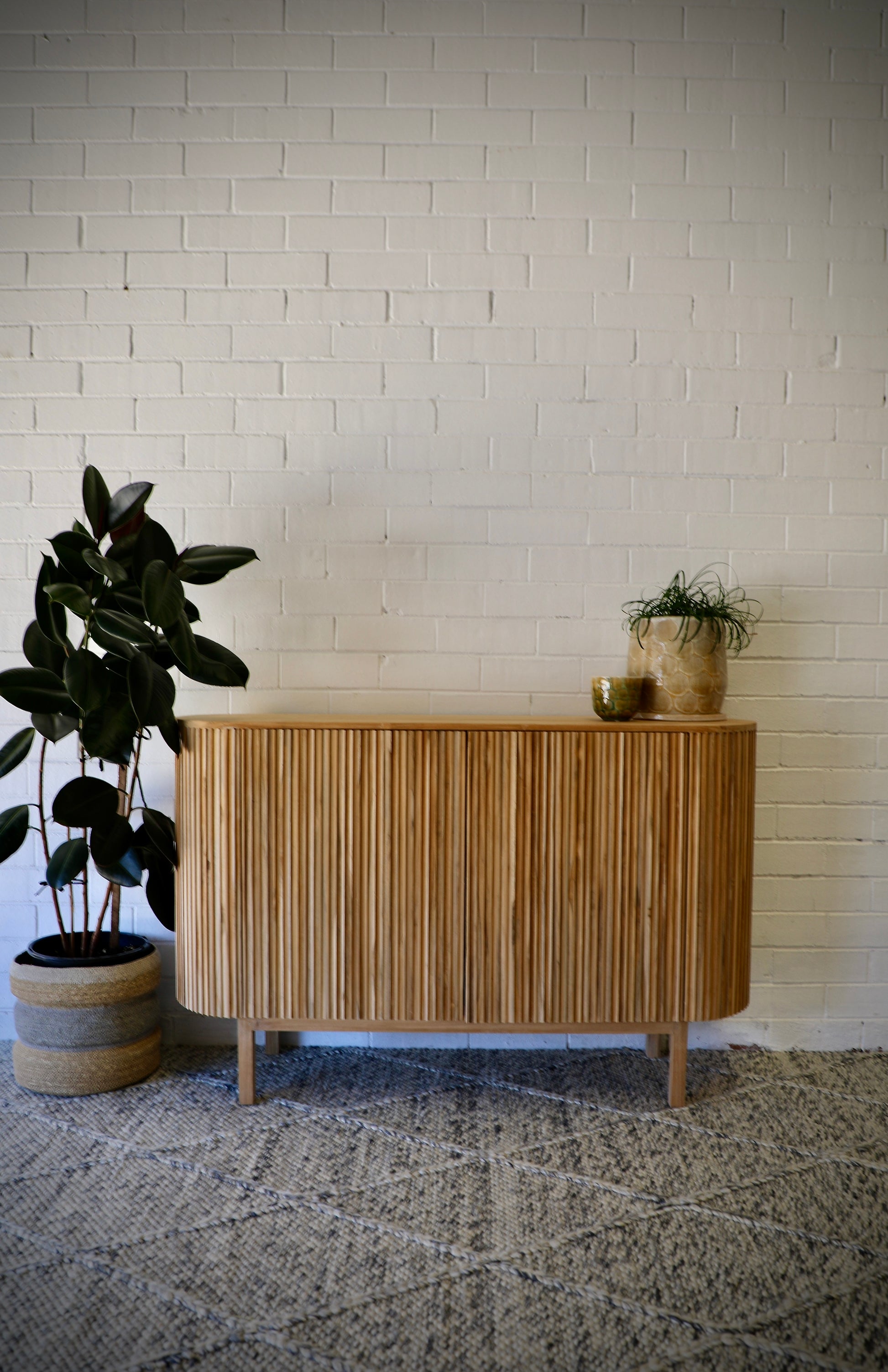 The Medford 2 Door Buffet. Crafted from solid teak, with rounded sides and sits on sleek legs. Colour Natural. Measures 1250L X 350D X 800H. Front Styled.
