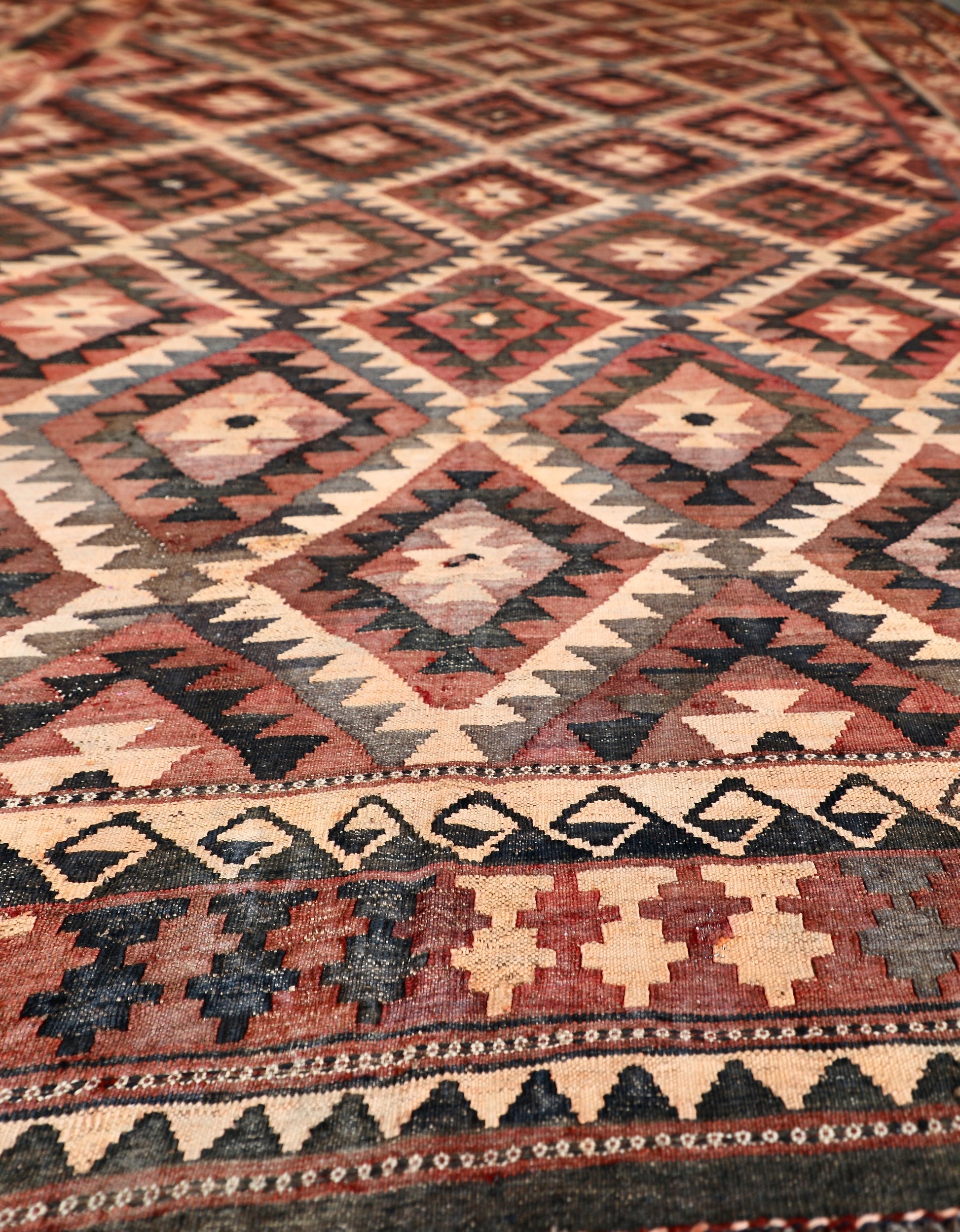 The Afghan Hand Woven Maimana Kilim - 251 X 344.  Crafted from wool and featuring traditional Afghan weaving techniques. Colours, red, orange, black. Size 251 wide X 344 long. Angle.