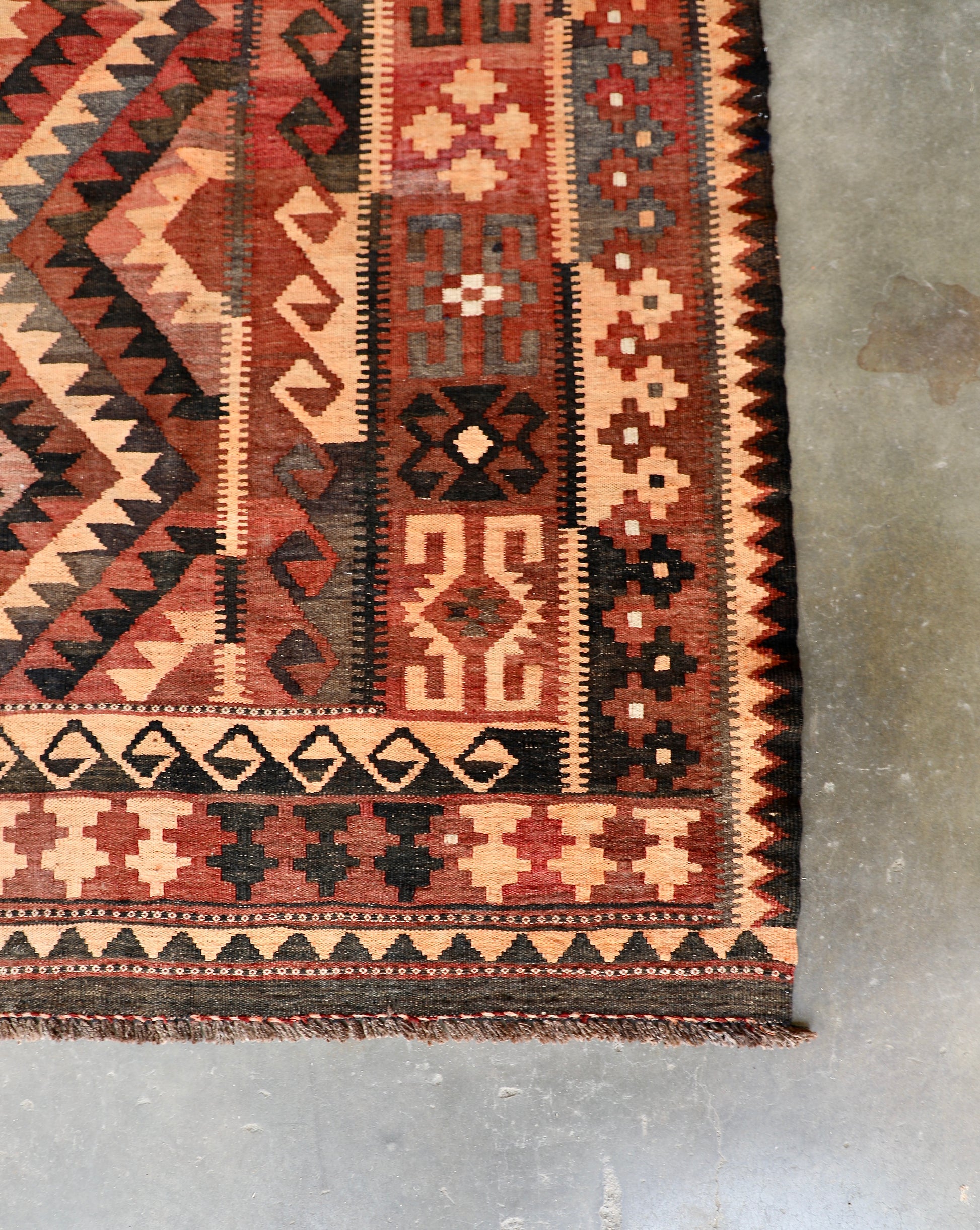 The Afghan Hand Woven Maimana Kilim - 251 X 344.  Crafted from wool and featuring traditional Afghan weaving techniques. Colours, red, orange, black. Size 251 wide X 344 long. Corner.