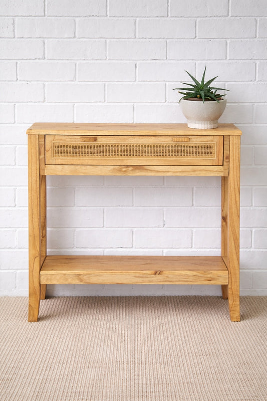 The Milan - 1 Drawer Natural console boasts coastal and contemporary style. Crafted from sustainable white cedar timber, it features 1 drawer, on wooden runners, and an open mesh rattan drawer face. Colour Natural. Measures 800 length X 250 depth X 750 height. Styled.