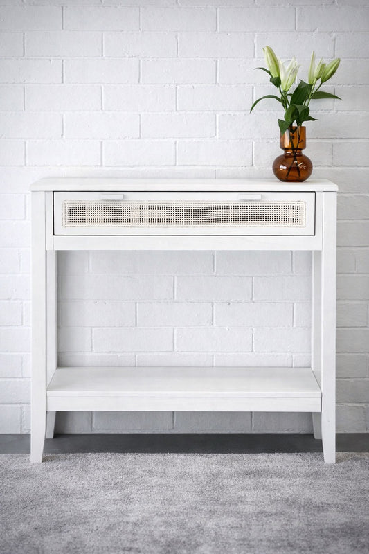 The Milan - 1 Drawer White console boasts coastal and contemporary style. Crafted from sustainable white cedar timber, it features 1 drawer, on wooden runners, and an open mesh rattan drawer face. Colour White. Measures 800 length X 250 depth X 750 height. Styled.
