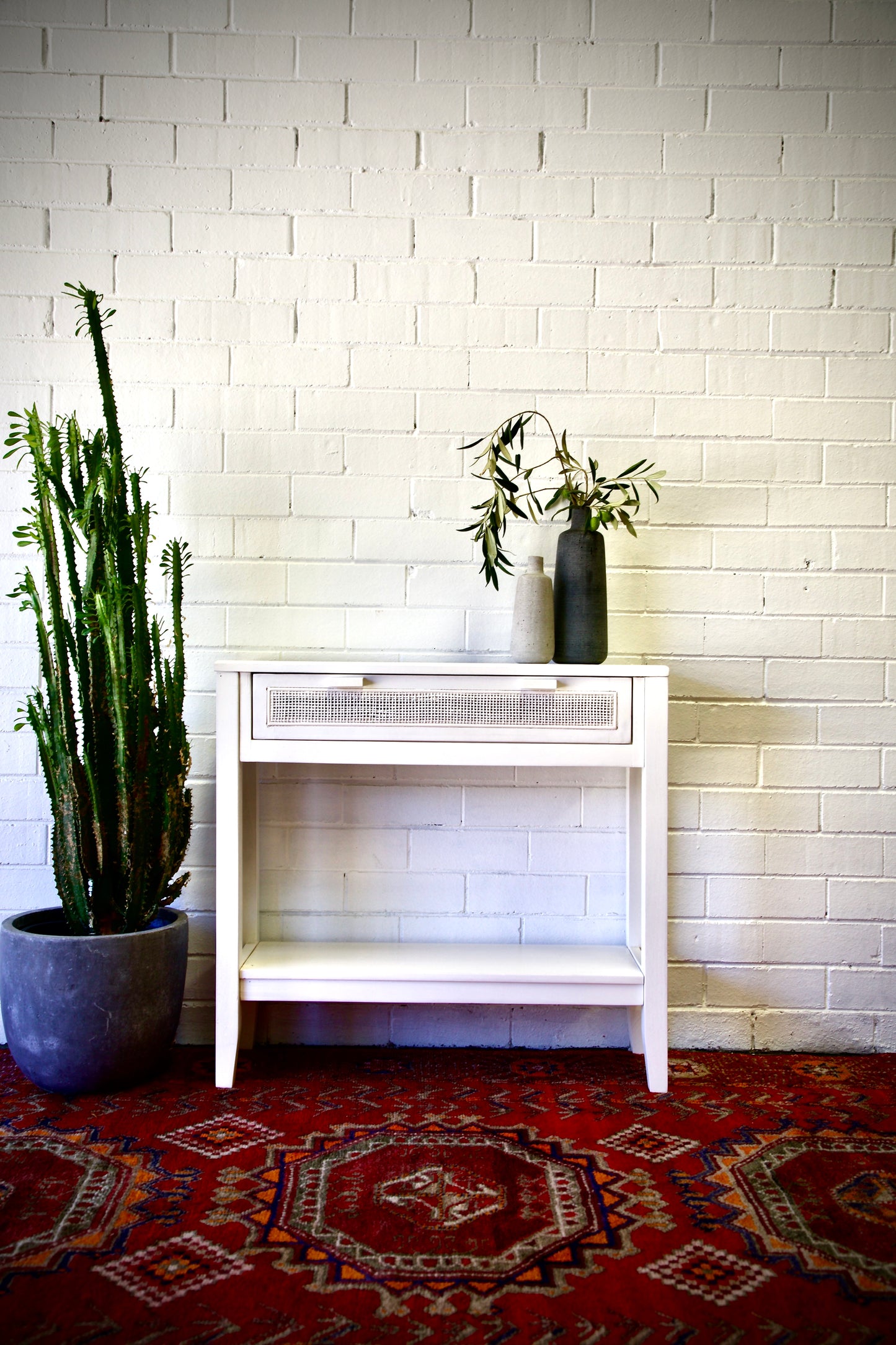 The Milan - 1 Drawer White console boasts coastal and contemporary style. Crafted from sustainable white cedar timber, it features 1 drawer, on wooden runners, and an open mesh rattan drawer face. Colour White. Measures 800 length X 250 depth X 750 height. Front Styled.
