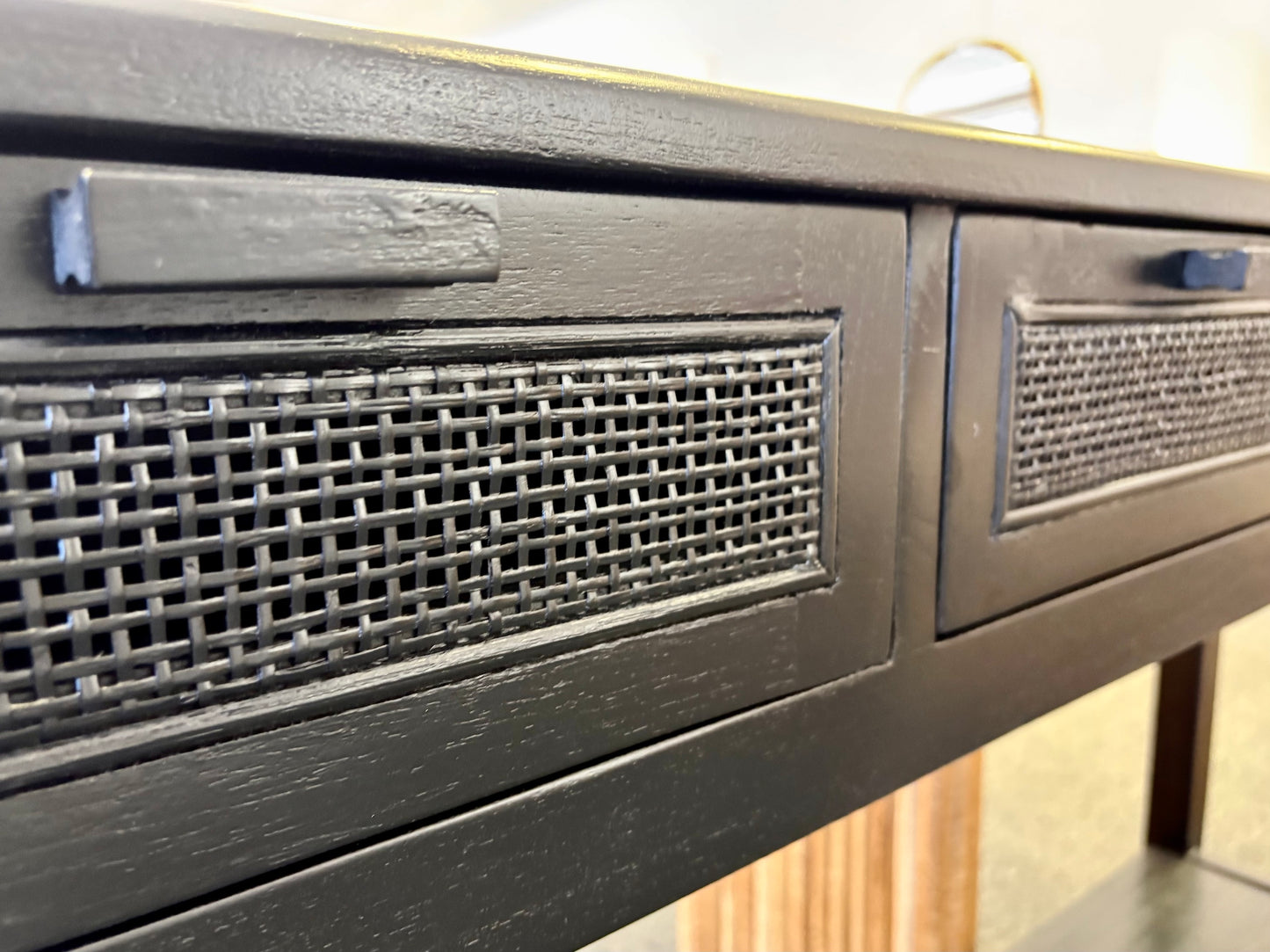 The Milan 2 Drawer Black console boasts coastal and contemporary style. Crafted from sustainable white cedar timber, it features 2 drawers, on wooden runners, and an open mesh rattan drawer face. Colour Black. Measures 1500 length X 250 depth X 750 height. Angle.