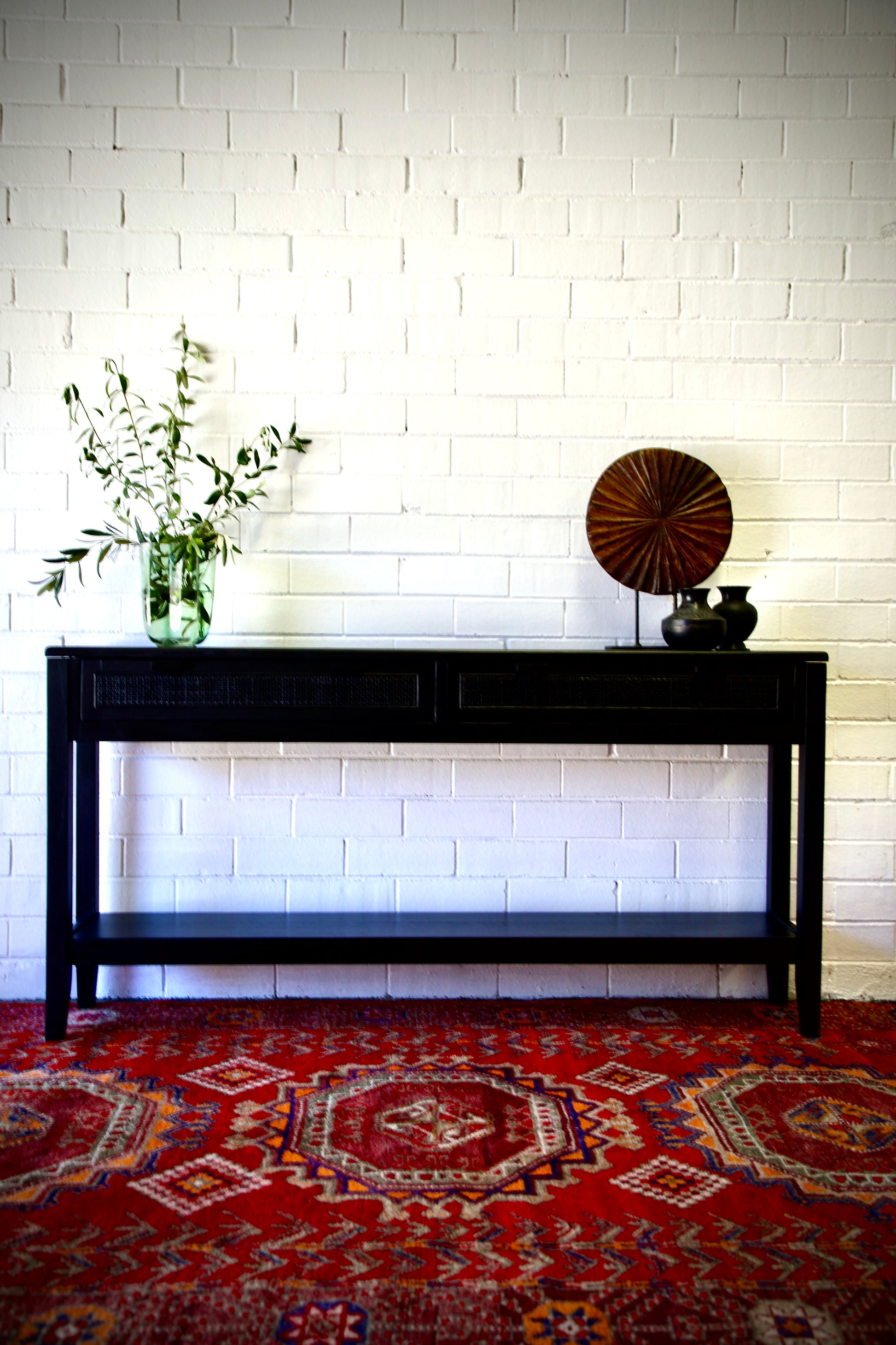 The Milan 2 Drawer Black console boasts coastal and contemporary style. Crafted from sustainable white cedar timber, it features 2 drawers, on wooden runners, and an open mesh rattan drawer face. Colour Black. Measures 1500 length X 250 depth X 750 height. Front Styled.