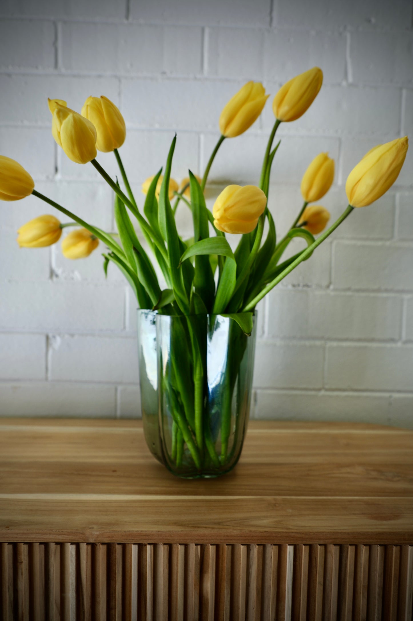 The Miranda Glass Vase is a modern/contemporary piece. Features a curved design. Colour mint green. Measures 15 Diameter X 20 Height. Styled.