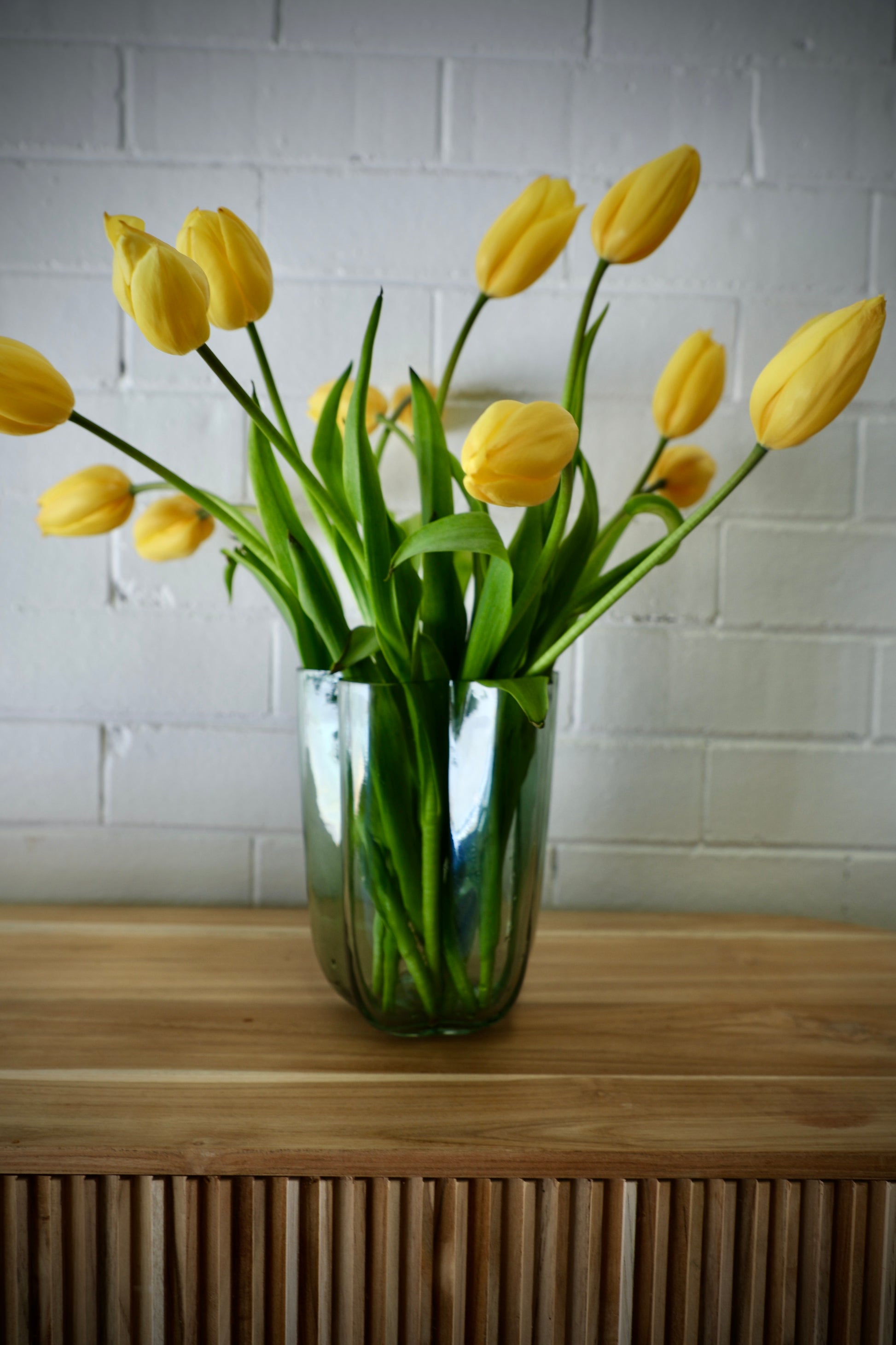 The Miranda Glass Vase is a modern/contemporary piece. Features a curved design. Colour mint green. Measures 15 Diameter X 20 Height. Styled.