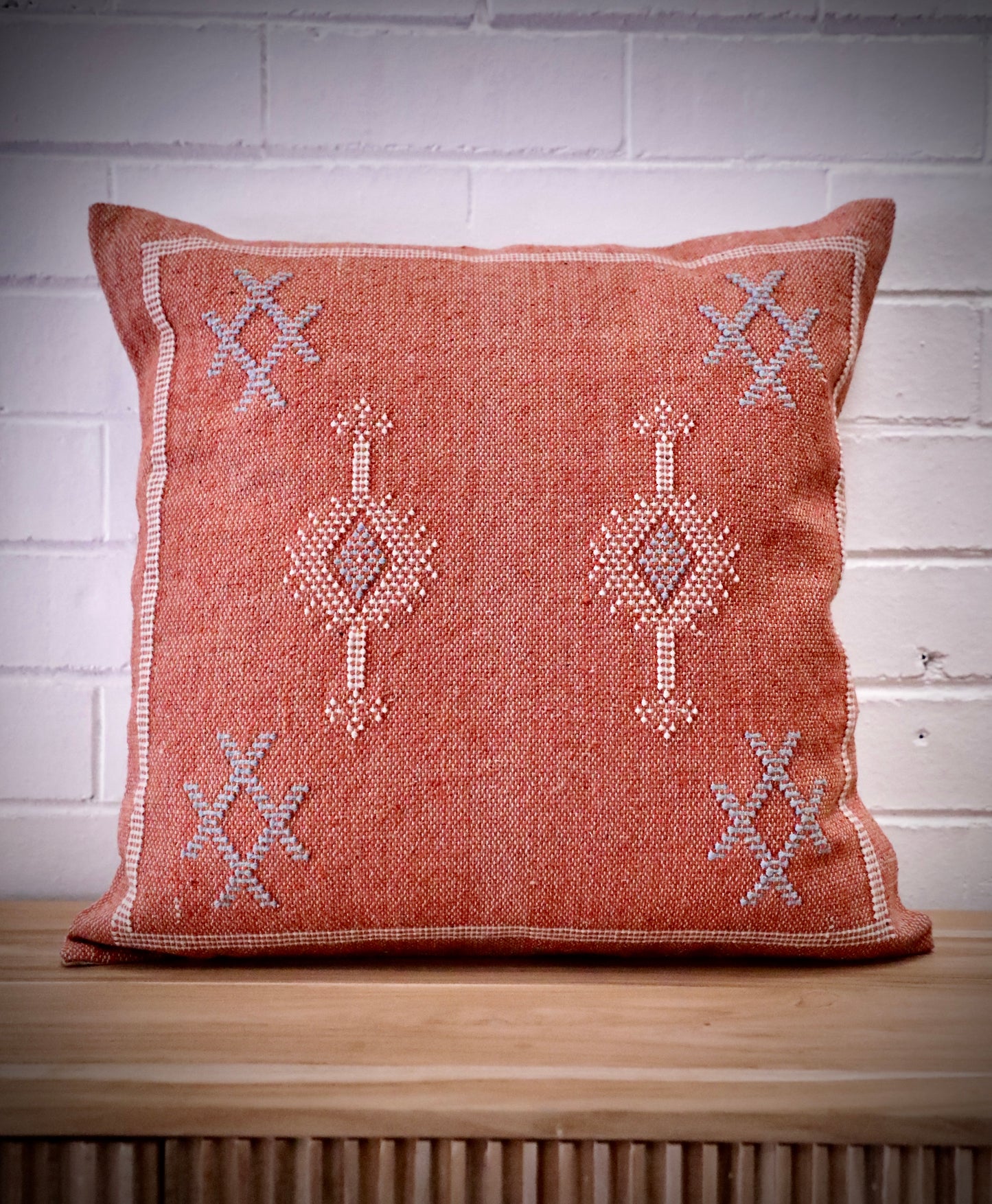 The Moroccan Burnt Orange Cushion is hand crafted in India. Features a cotton weave with hidden zip on the back. This Moroccan inspired design will bring a boho feel to any area. Colours, orange, cream and blues. Measures 50 X 50. Front.