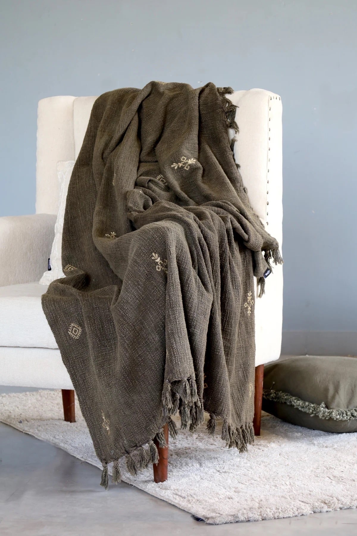 Ochoco Evergreen throw blanket styled over a with arm chair.