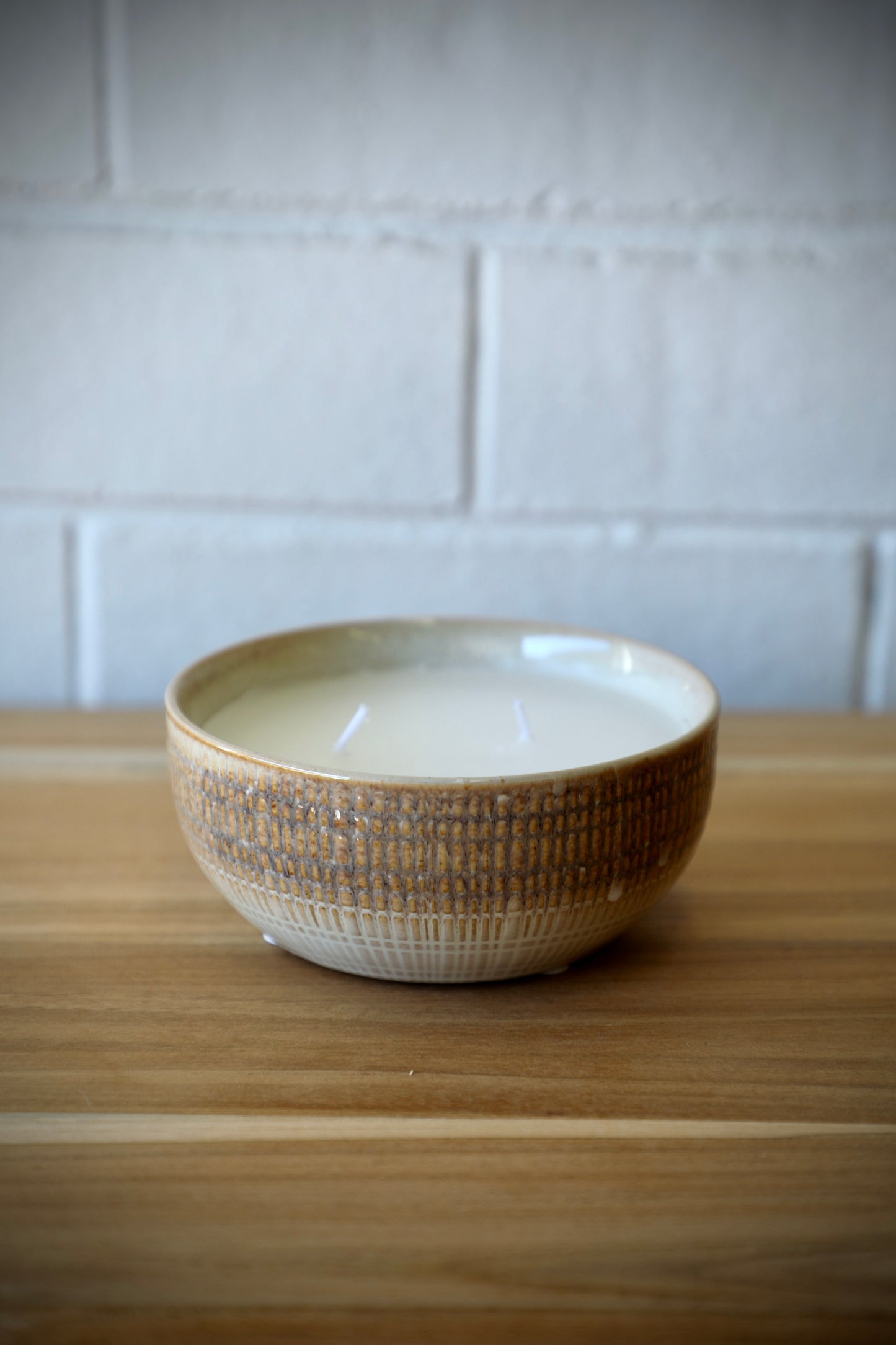 The Ondat Ceramic Candle Pot features a textured outer shell.  Its Seasalt scent provides a soothing sense to any room.  Colours, beige, cream and browns. Measures 13.5 Diameter X 5.5 Height. Side Styled