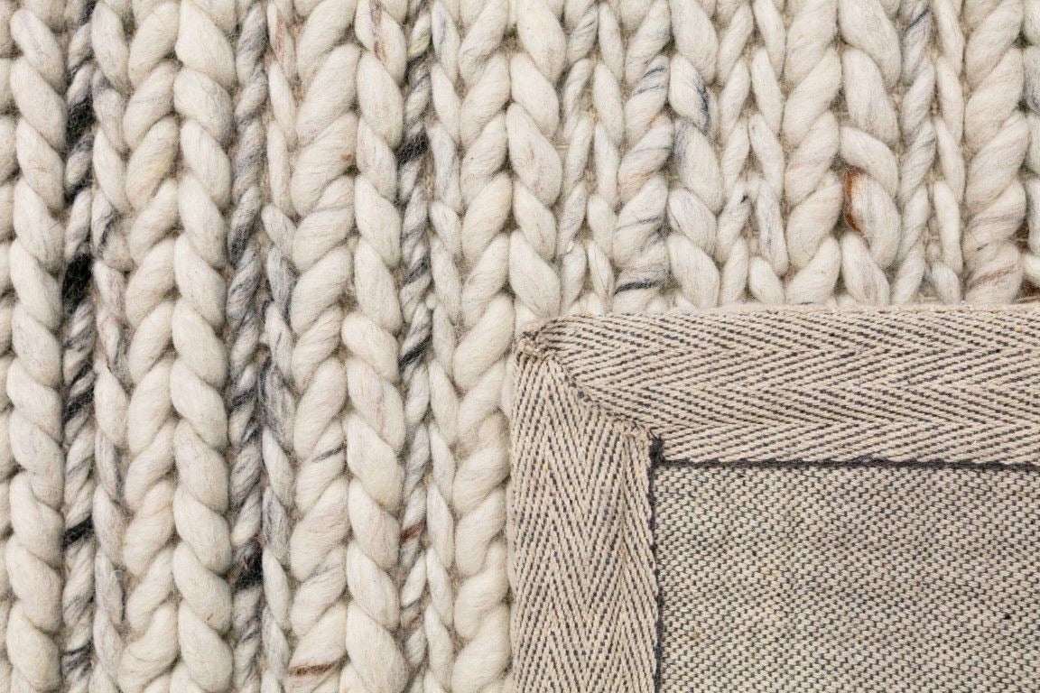 Oslo Braided is a textured hand woven,  braided piled wool rug. Colours white with grey,  black and brown accents. Sizes 155 X 225, 200 X 290, 240 X 320 and 300 X 400. Fold.