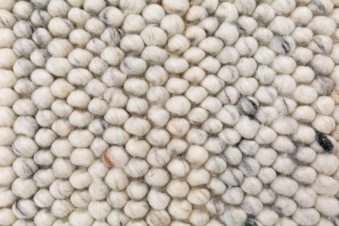 Oslo Bubble is a textured hand woven,  looped piled wool rug. Colours white with grey,  black and brown accents. Sizes 155 X 225, 200 X 290, 240 X 320 and 300 X 400. Close.