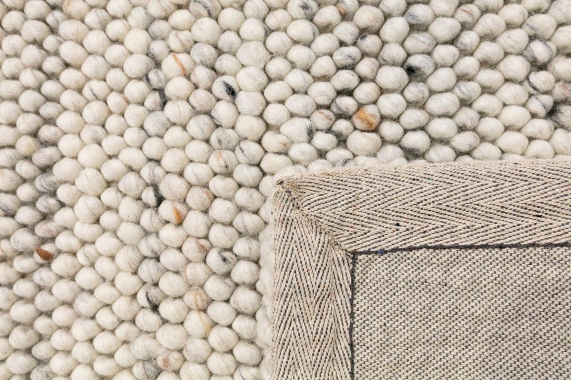 Oslo Bubble is a textured hand woven,  looped piled wool rug. Colours white with grey,  black and brown accents. Sizes 155 X 225, 200 X 290, 240 X 320 and 300 X 400. Fold.