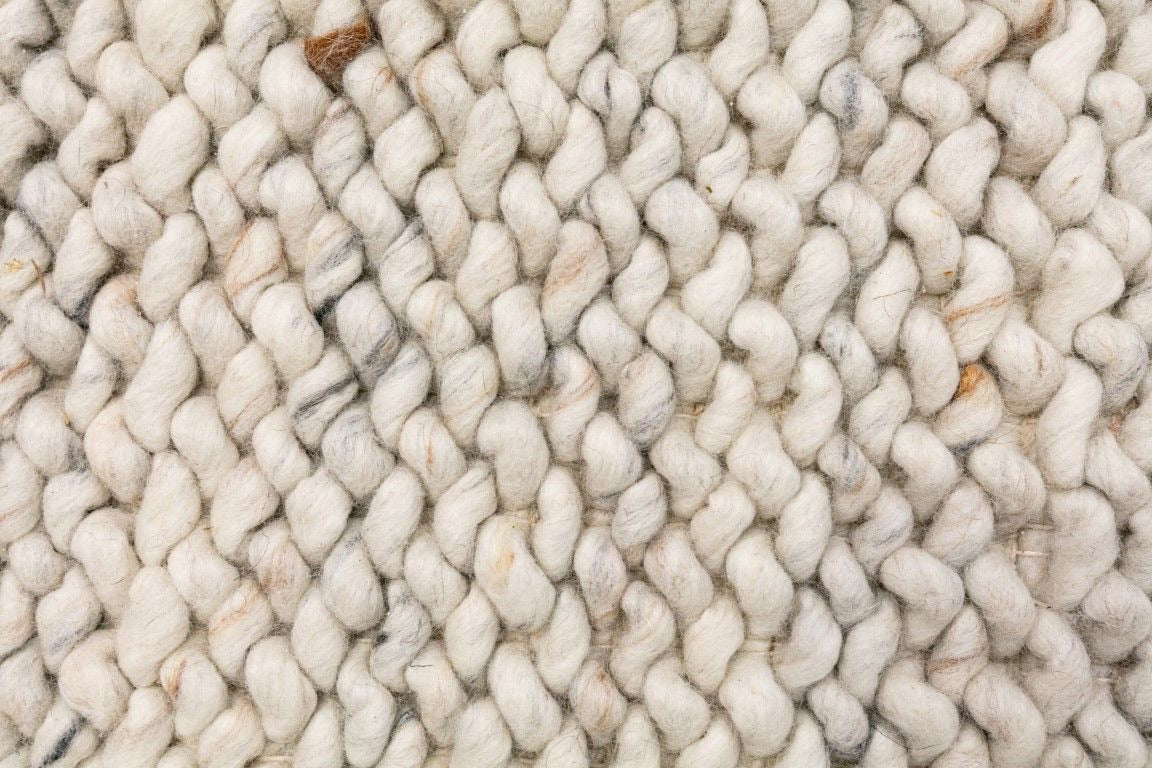 Oslo Loop is a textured hand woven, piled loop wool rug. Colours white with grey,  black and brown accents. Sizes 155 X 225, 200 X 290, 240 X 320 and 300 X 400. Close.