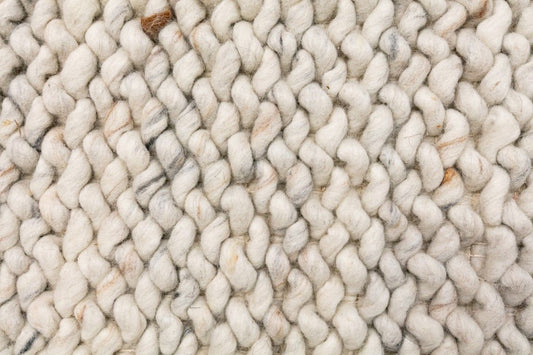 Oslo Loop is a textured hand woven, piled loop wool rug. Colours white with grey,  black and brown accents. Sizes 155 X 225, 200 X 290, 240 X 320 and 300 X 400. Close.