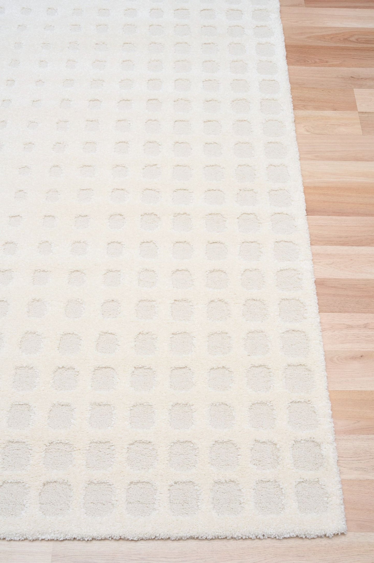 Osmond Squares Ivory rug with soft square patterns in a neutral palette and a high-low textured finish. Colours Ivory and Light Grey. Sizes 160 X 230, 200 X 290 and 240 X 340. Corner.