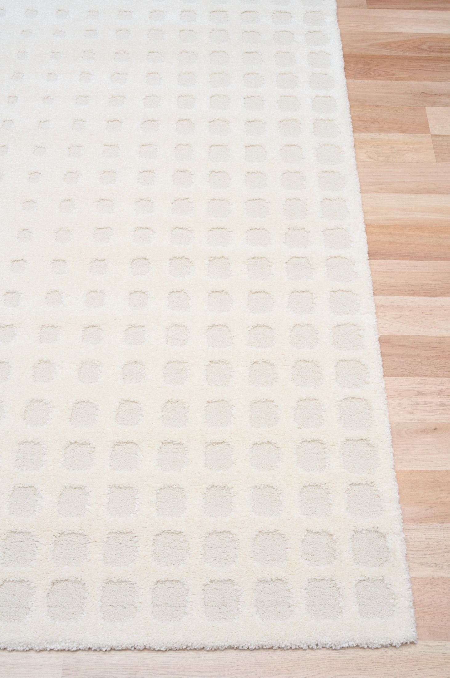 Osmond Squares Ivory rug with soft square patterns in a neutral palette and a high-low textured finish. Colours Ivory and Light Grey. Sizes 160 X 230, 200 X 290 and 240 X 340. Corner.