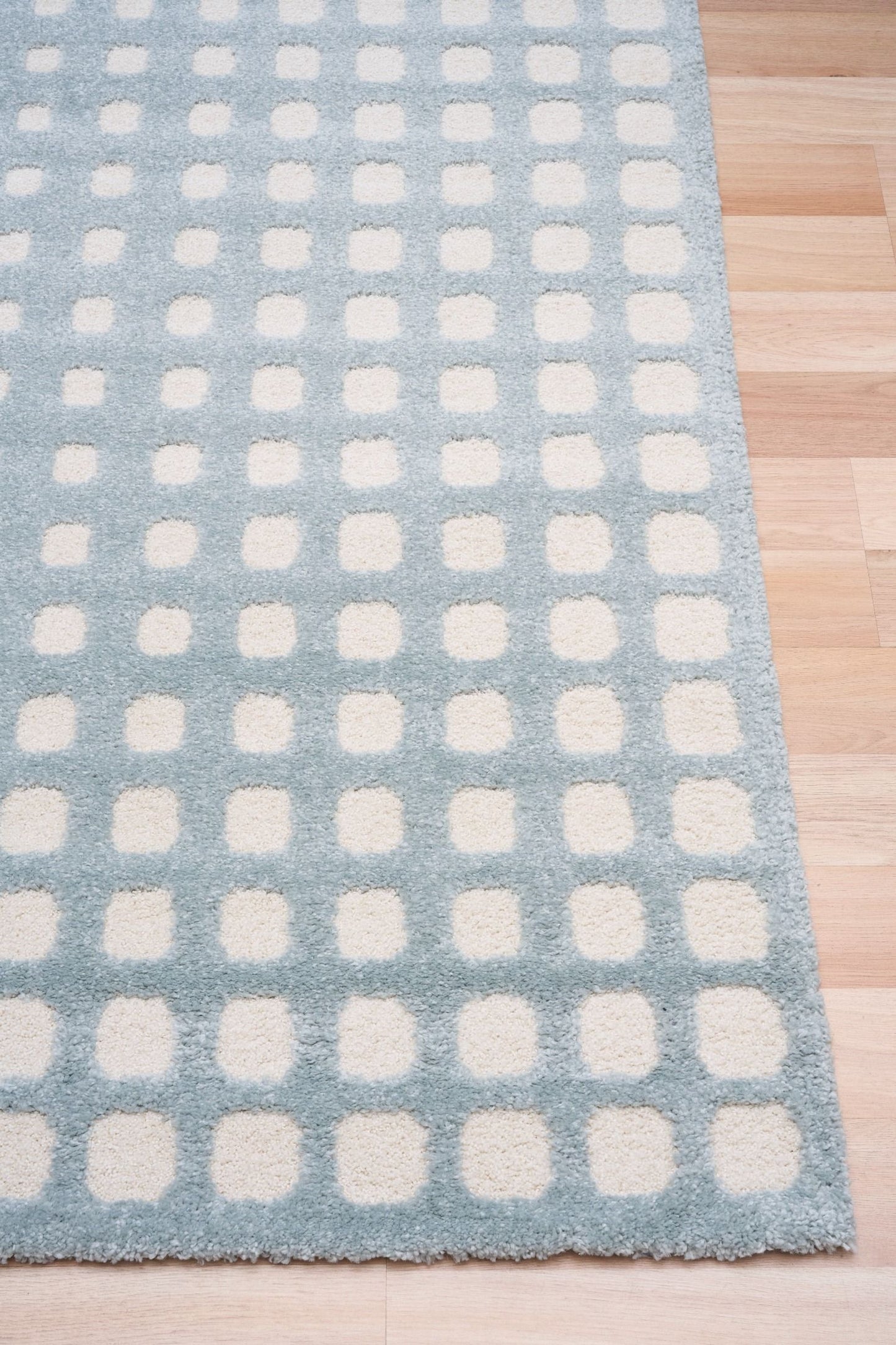 Osmond Squares Light Blue rug with soft square patterns in a neutral palette and a high-low textured finish. Colours Light Blue and Ivory. Sizes 160 X 230, 200 X 290 and 240 X 340. Corner.