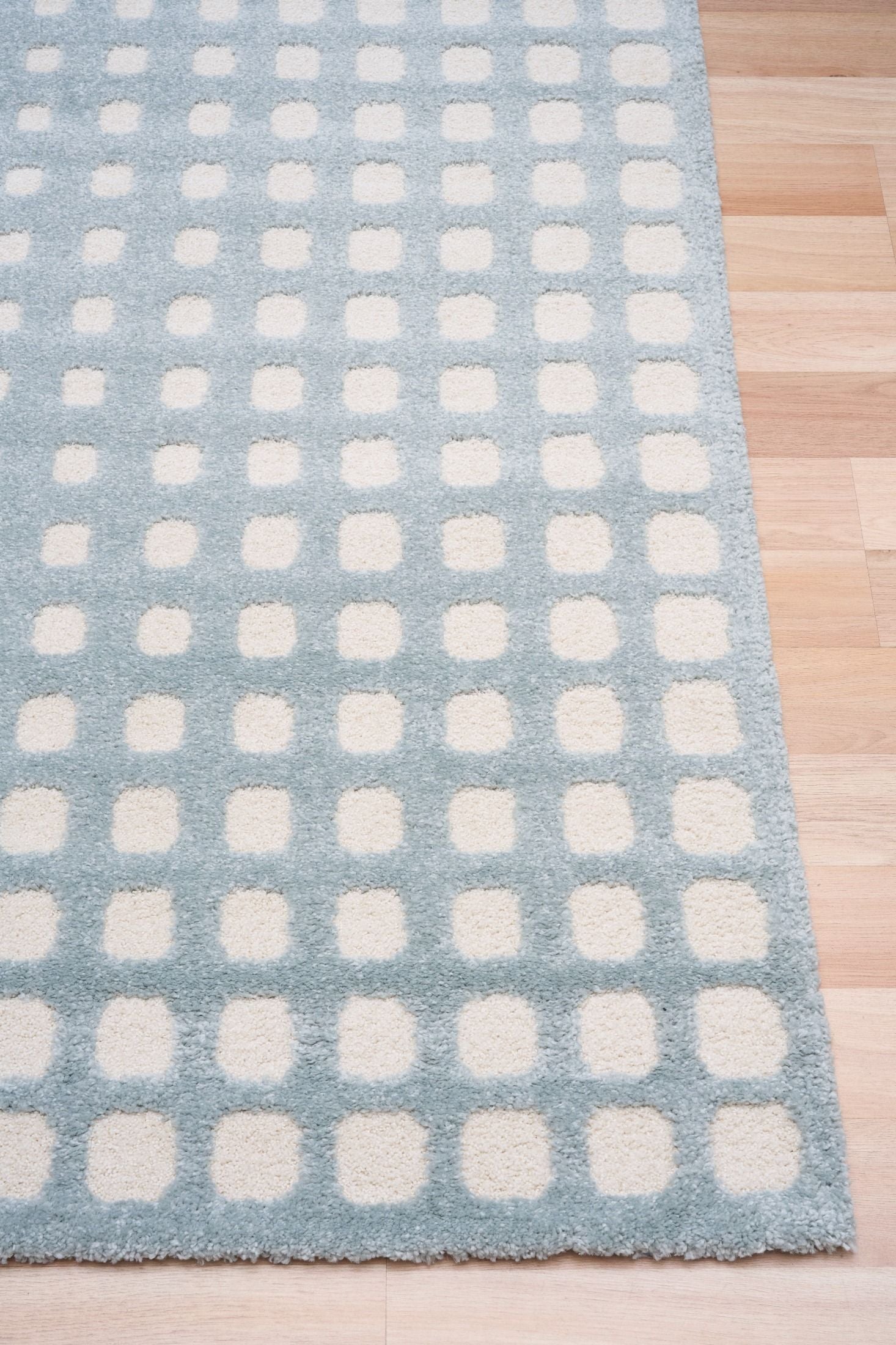 Osmond Squares Light Blue rug with soft square patterns in a neutral palette and a high-low textured finish. Colours Light Blue and Ivory. Sizes 160 X 230, 200 X 290 and 240 X 340. Corner.