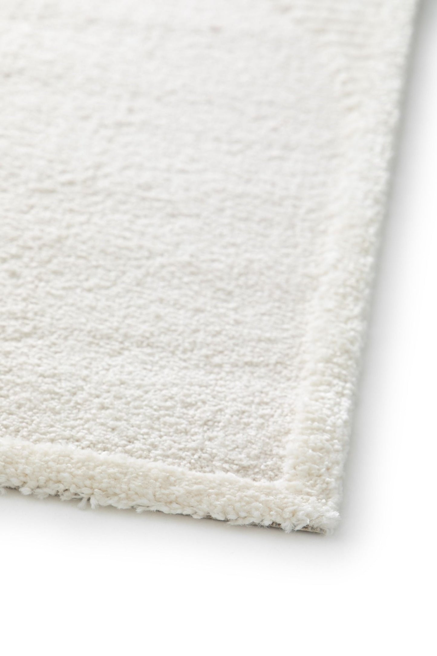 Osmond Waves Ivory rug with soft geometric patterns in a neutral palette and a high-low textured finish. Colours Ivory and Light Grey. Sizes 160 X 230, 200 X 290 and 240 X 340. Angle Corner.
