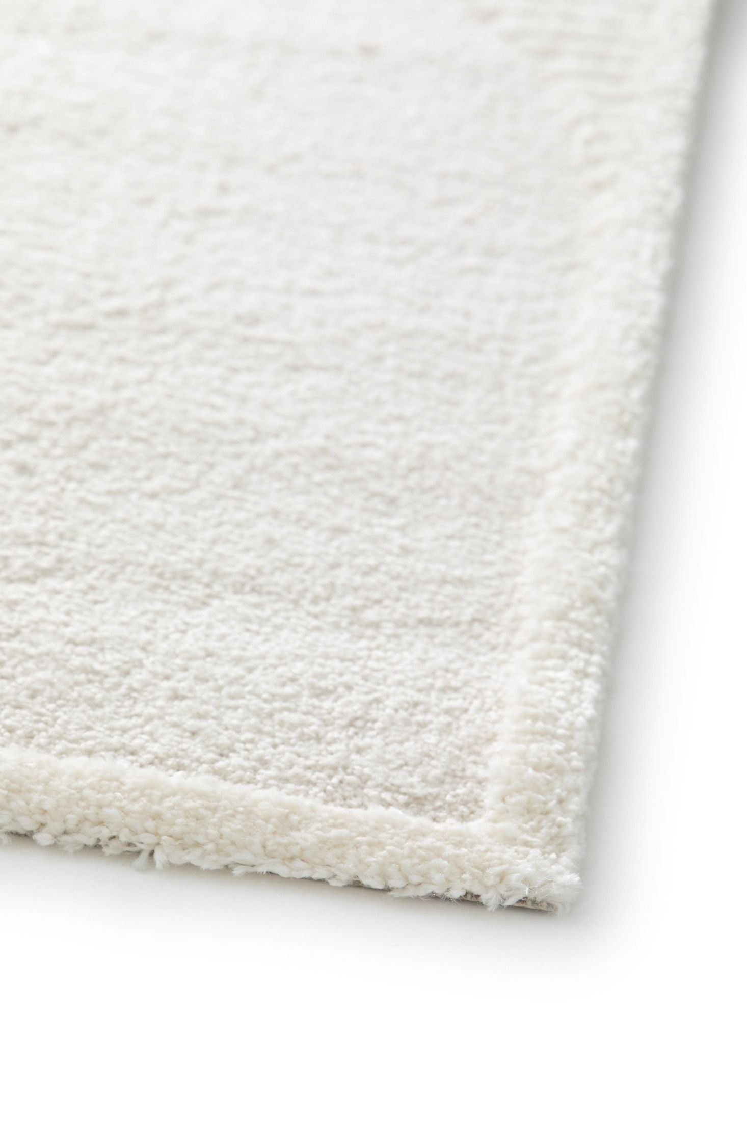 Osmond Waves Ivory rug with soft geometric patterns in a neutral palette and a high-low textured finish. Colours Ivory and Light Grey. Sizes 160 X 230, 200 X 290 and 240 X 340. Angle Corner.
