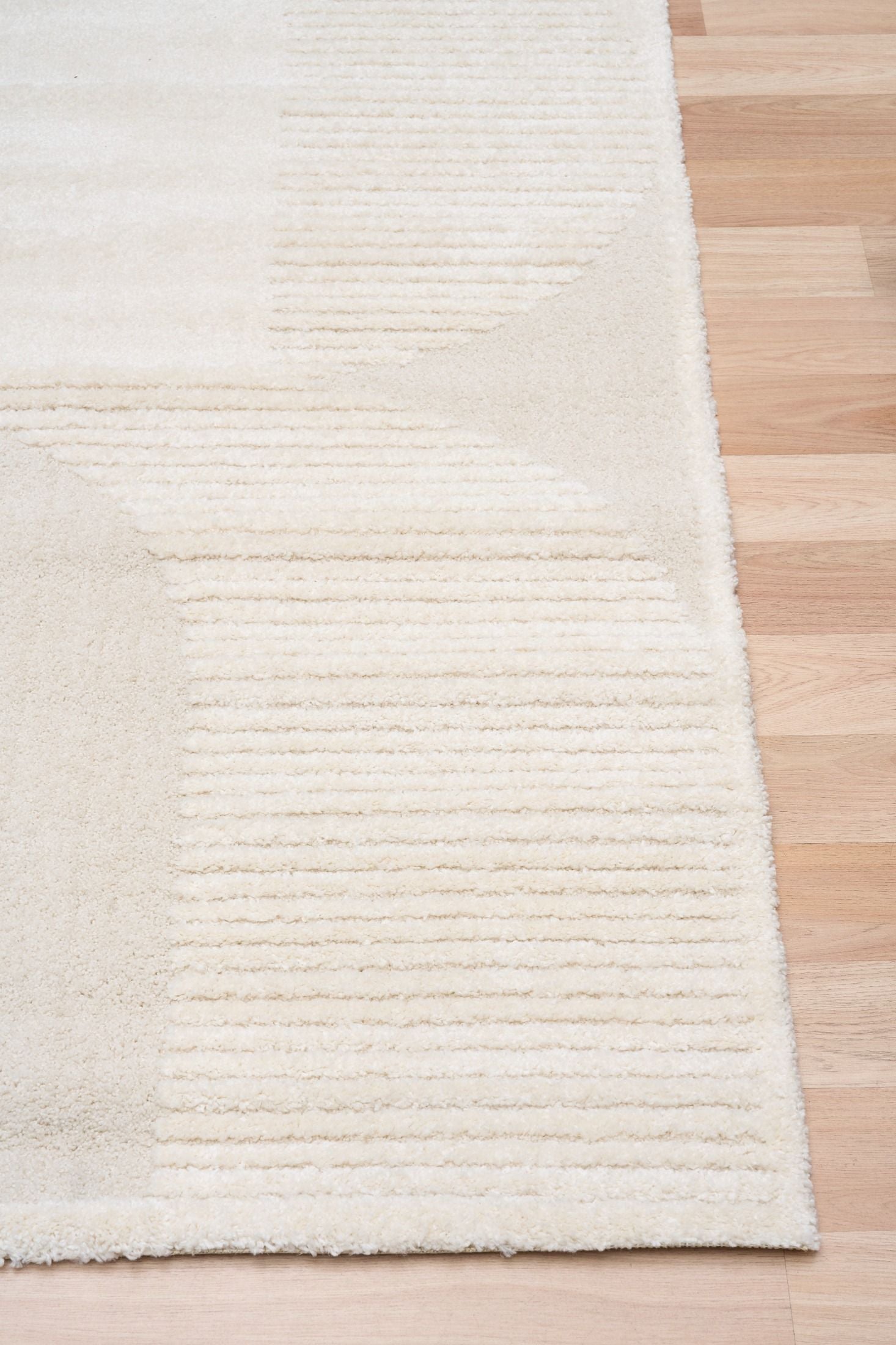 Osmond Waves Ivory rug with soft geometric patterns in a neutral palette and a high-low textured finish. Colours Ivory and Light Grey. Sizes 160 X 230, 200 X 290 and 240 X 340. Corner.