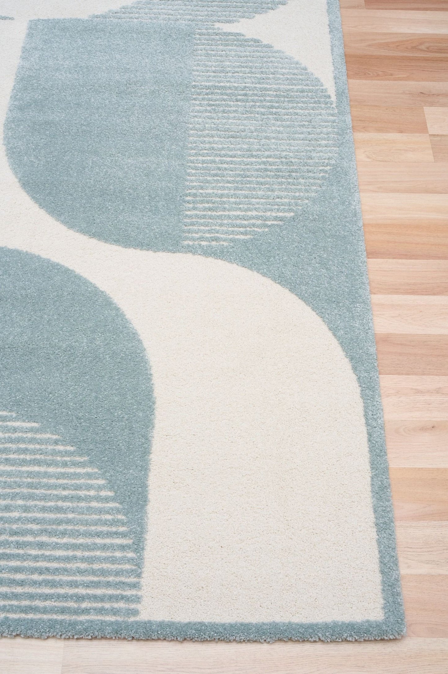 Osmond Waves Light Blue rug with soft geometric patterns in a neutral palette and a high-low textured finish. Colours Light Blue and Ivory. Sizes 160 X 230, 200 X 290 and 240 X 340. Corner.