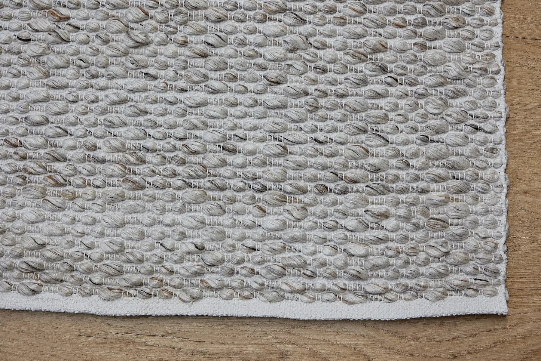 Oxford Taupe is a hand-braided rug with a contemporary design. Crafted with wool and polyester for a textured feel, the rug has a pile height of 7-9mm. Colour Cream with brownish accents. Sizes 160 X 230, 200 X 290, 240 X 340 and 300 X 400. Corner.
