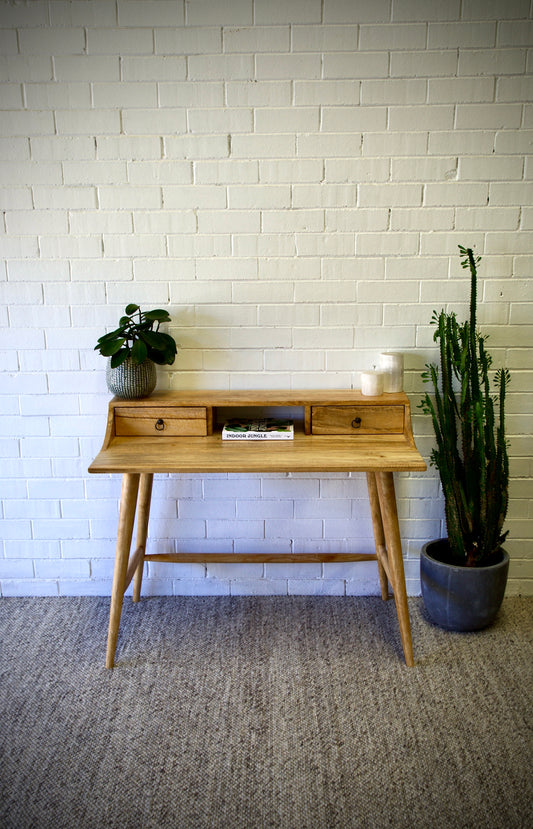 The Ozark Desk is crafted with a contemporary silhouette and two drawers on wooden runners, it boasts a solid fruitwood top, reinforced by sturdy turned legs. Colour natural. Measures 1100 length X 600 depth X 750 height. Front Styled.