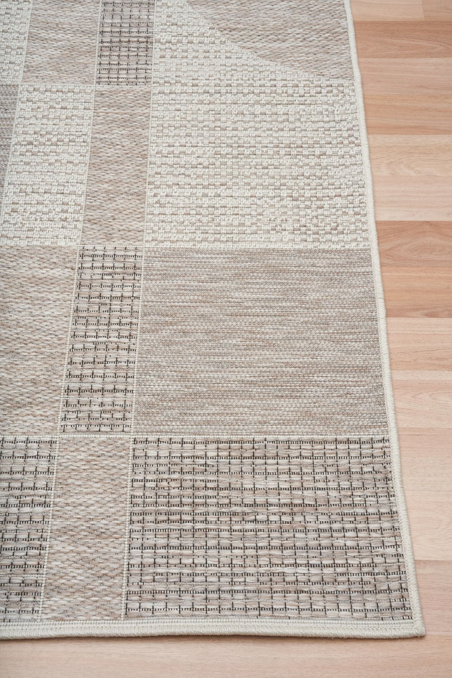 The Patio Linen 606 indoor/outdoor rug featuring neutral tones and a modern designed pattern, power-loomed from UV-stabilised polypropylene for lasting durability. Colours, Linen, Beiges and hints of light grey. 3 sizes. Corner.