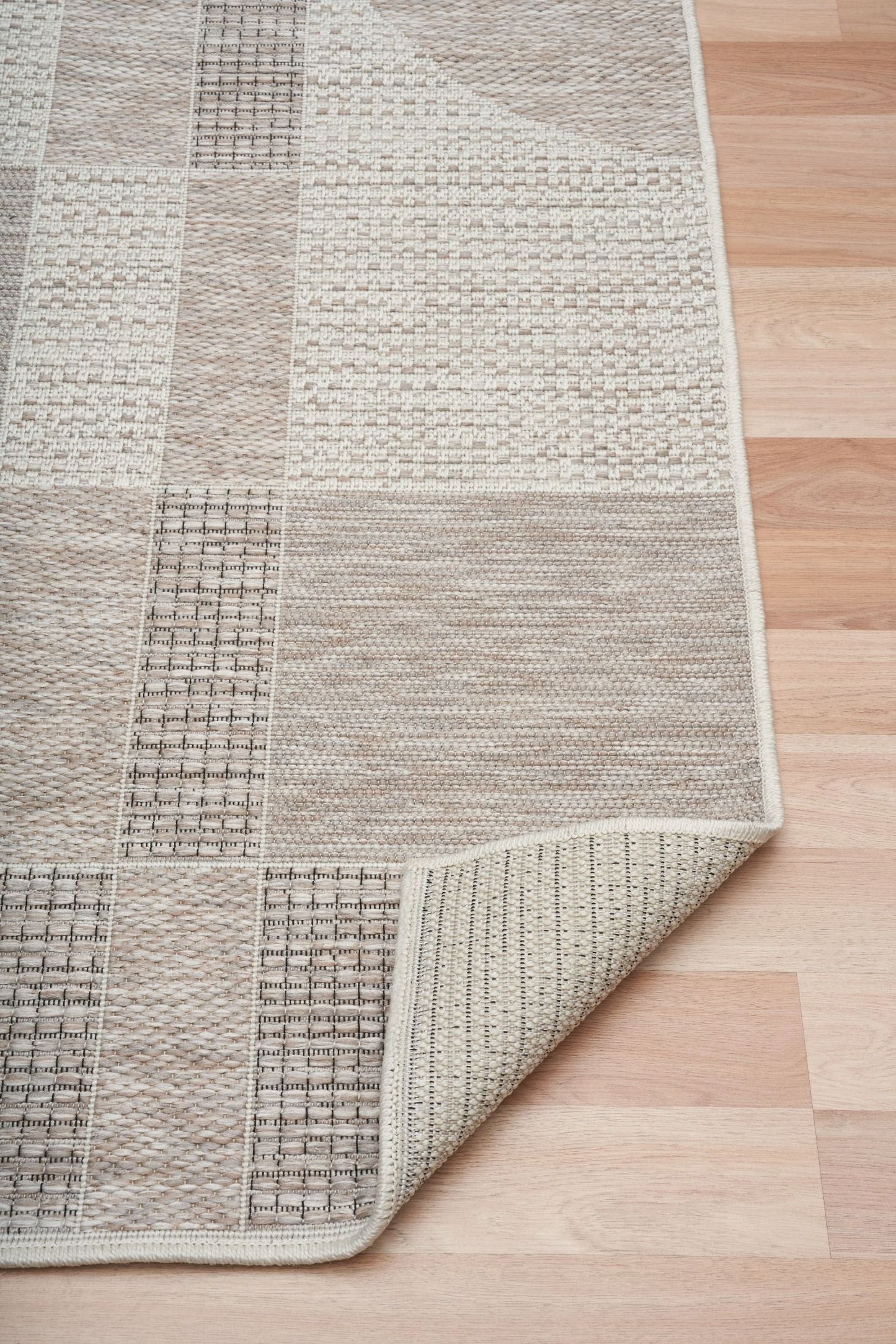 The Patio Linen 606 indoor/outdoor rug featuring neutral tones and a modern designed pattern, power-loomed from UV-stabilised polypropylene for lasting durability. Colours, Linen, Beiges and hints of light grey. 3 sizes. Fold.
