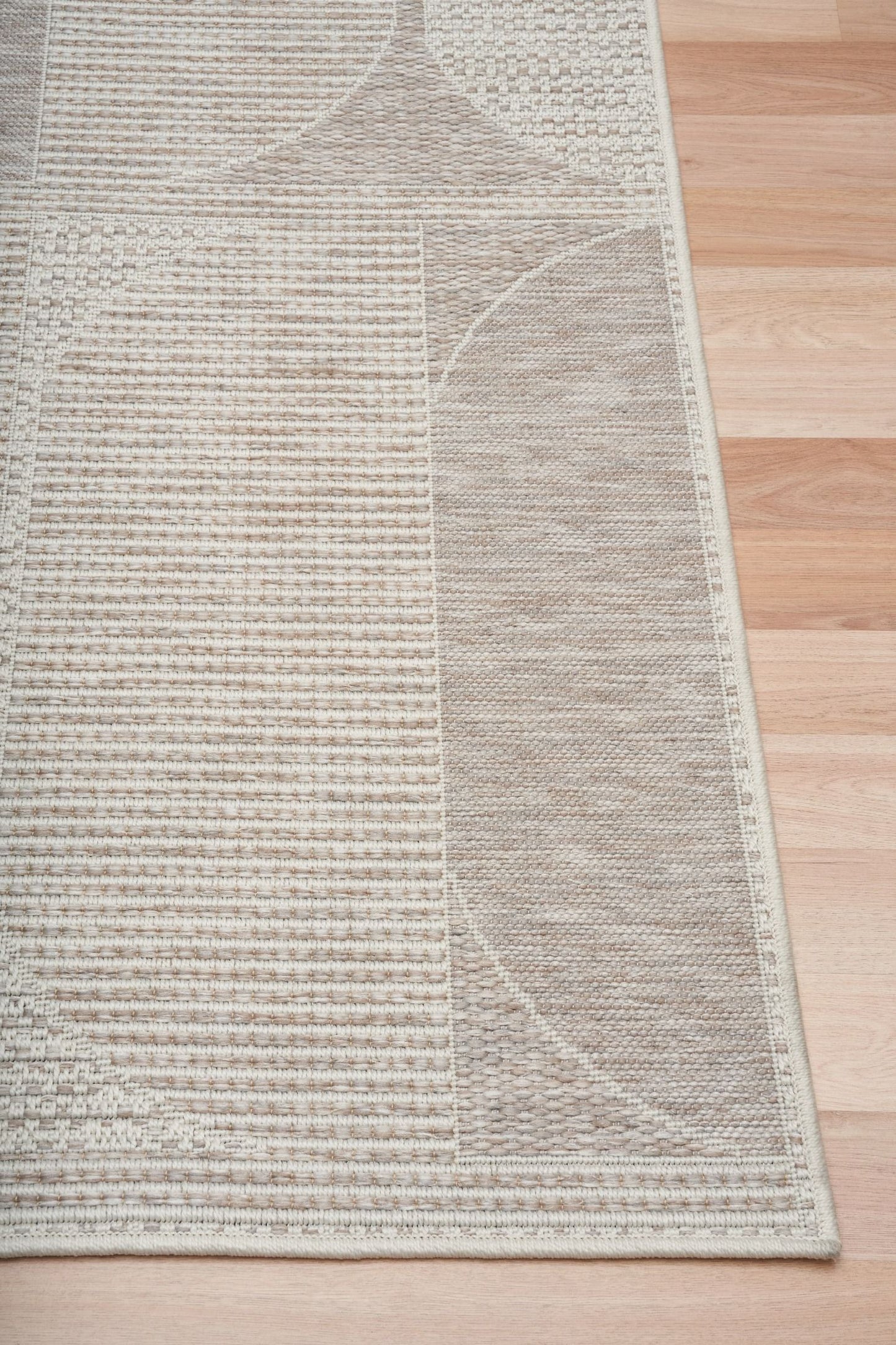 The Patio Linen 65001 indoor/outdoor rug featuring neutral tones and a modern designed pattern, power-loomed from UV-stabilised polypropylene for lasting durability. Colours, Linen, Beiges and hints of light grey. 3 sizes. Corner.