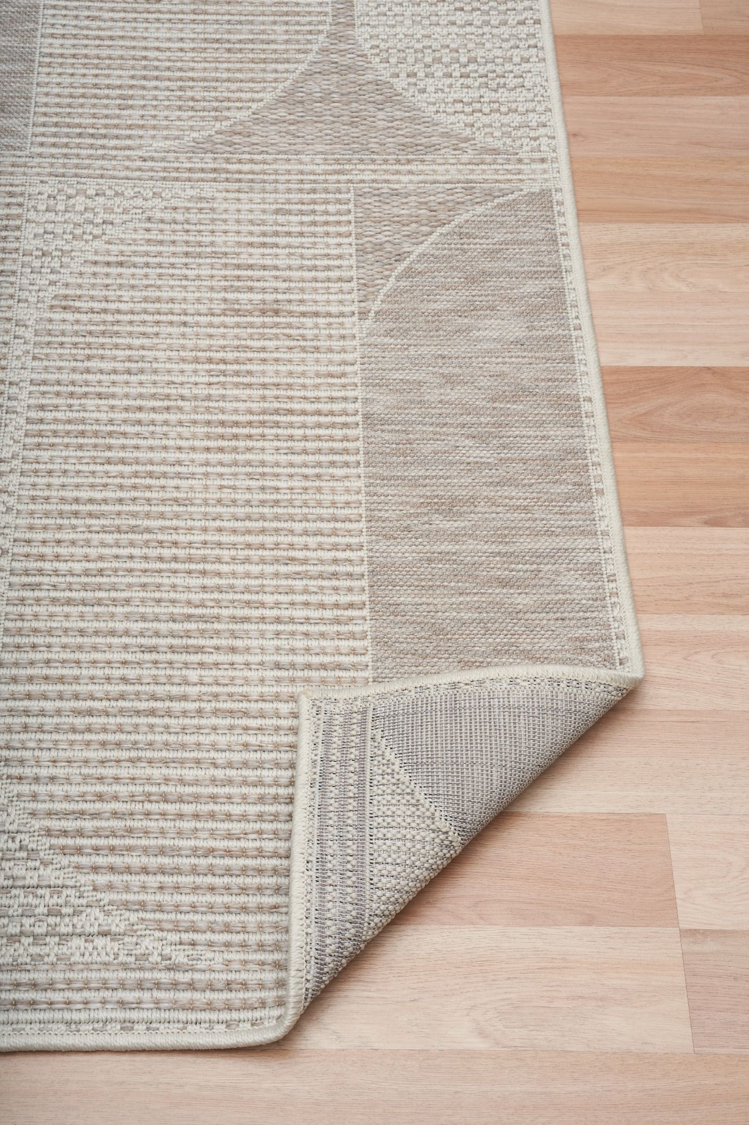 The Patio Linen 65001 indoor/outdoor rug featuring neutral tones and a modern designed pattern, power-loomed from UV-stabilised polypropylene for lasting durability. Colours, Linen, Beiges and hints of light grey. 3 sizes. Fold.