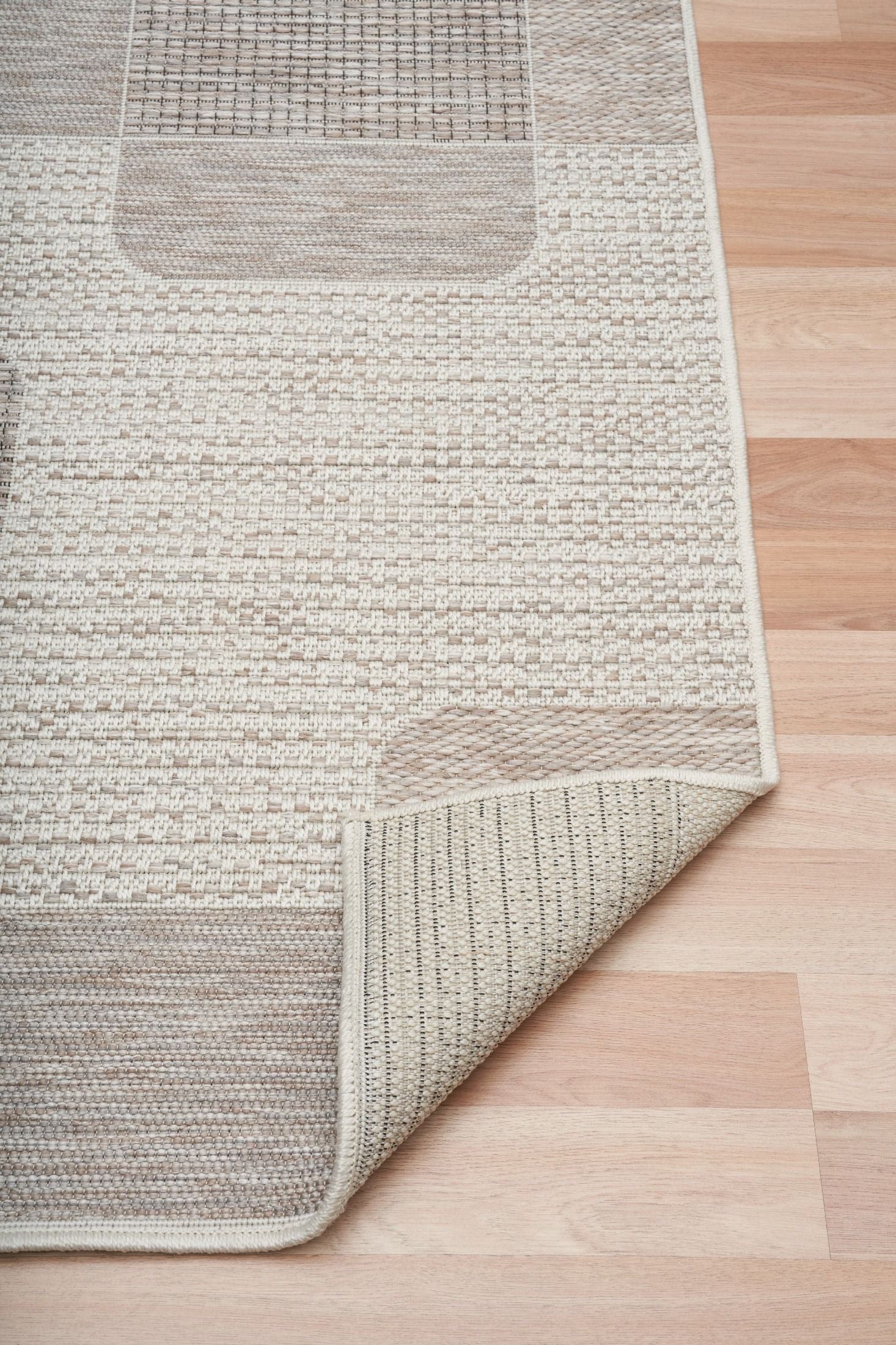 The Patio Squares Linen indoor/outdoor rug featuring neutral tones and a modern designed pattern, power-loomed from UV-stabilised polypropylene for lasting durability. Colours, Linen, Beiges and hints of light grey. 3 sizes. Fold.