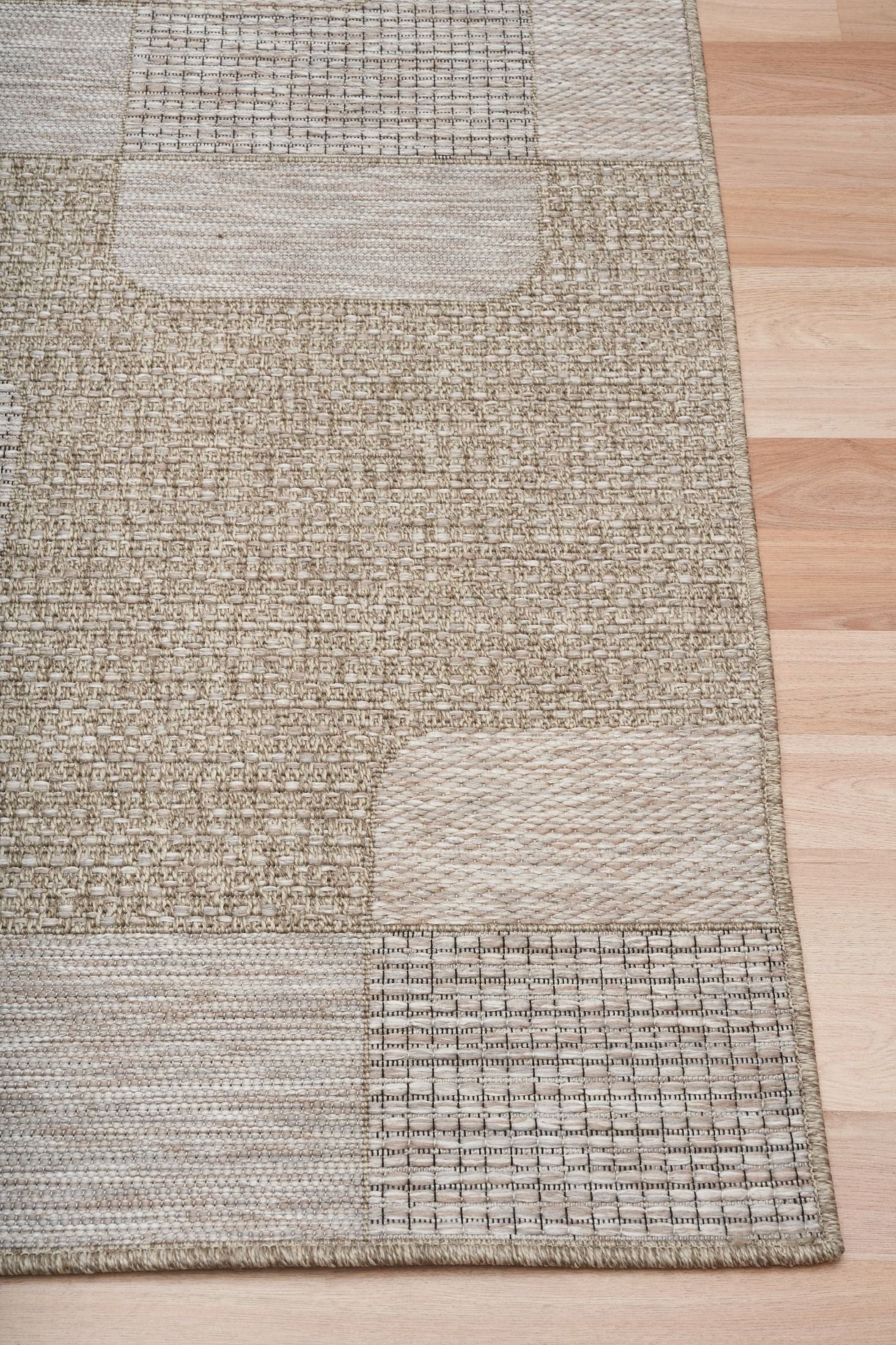 The Patio Squares Straw indoor/outdoor rug featuring neutral tones and a modern designed pattern, power-loomed from UV-stabilised polypropylene for lasting durability. Colours, Linen, Beiges and hints of light grey. 3 sizes. Corner.