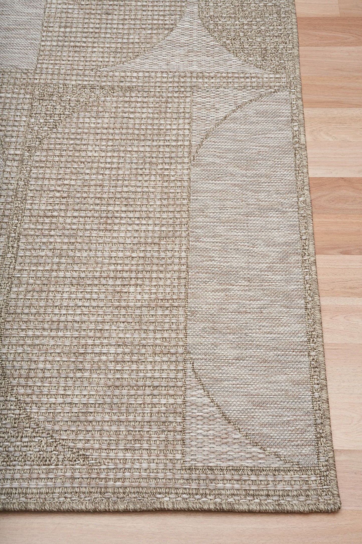 The Patio Straw 65001 indoor/outdoor rug featuring neutral tones and a modern designed pattern, power-loomed from UV-stabilised polypropylene for lasting durability. Colours, Linen, Beiges and hints of light grey. 3 sizes. Corner.
