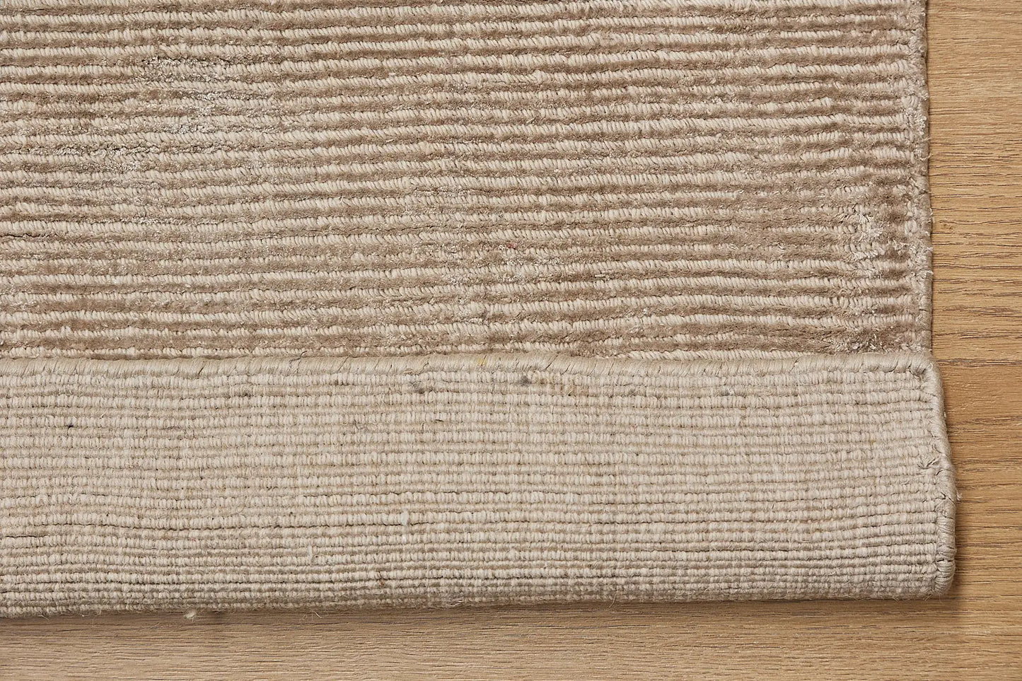 Pearl Coral is a luxurious hand-loomed knotted rug made with wool and silky viscose. It boasts a ribbed texture and pile height of 12-14mm. Colour Light Beige. Sizes 160 X 230, 200 X 290 and 240 X 340. Fold.