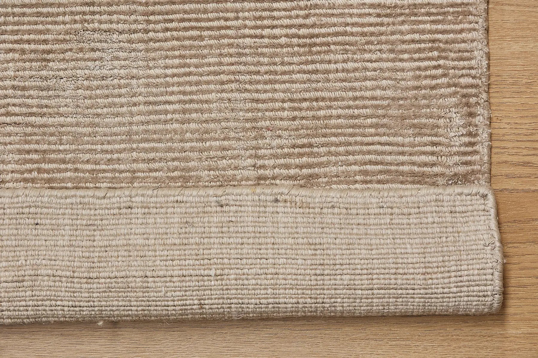 Pearl Coral is a luxurious hand-loomed knotted rug made with wool and silky viscose. It boasts a ribbed texture and pile height of 12-14mm. Colour Light Beige. Sizes 160 X 230, 200 X 290 and 240 X 340. Fold.