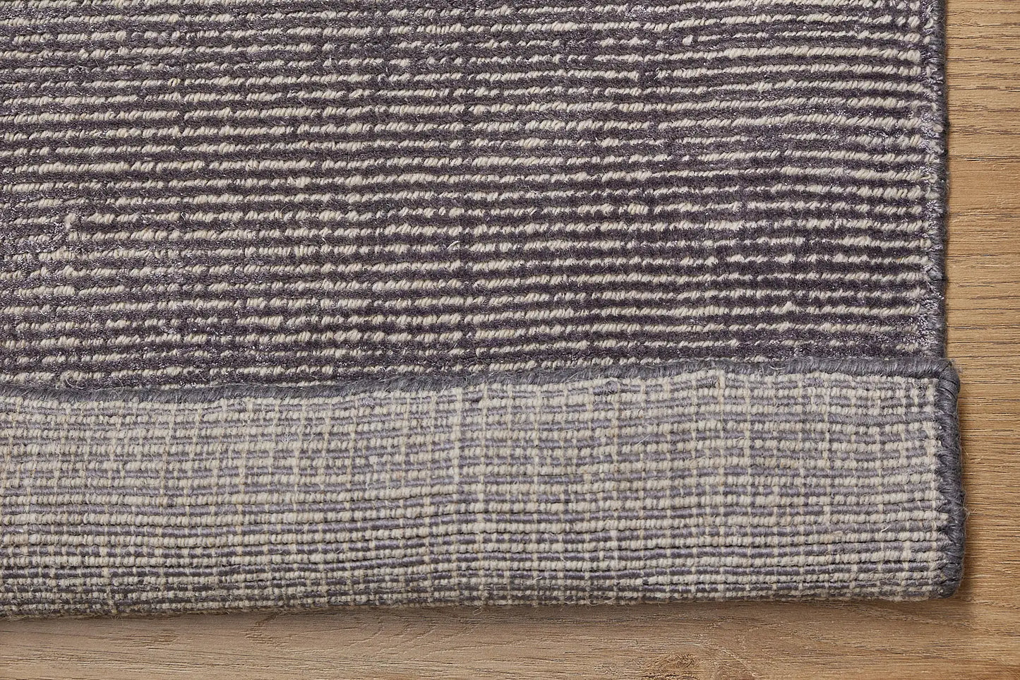 Pearl Garnet is a luxurious hand-loomed knotted rug made with wool and silky viscose. It boasts a ribbed texture and pile height of 12-14mm. Colour Blueish Grey with Beige accents. Sizes 160 X 230, 200 X 290 and 240 X 340. Fold.