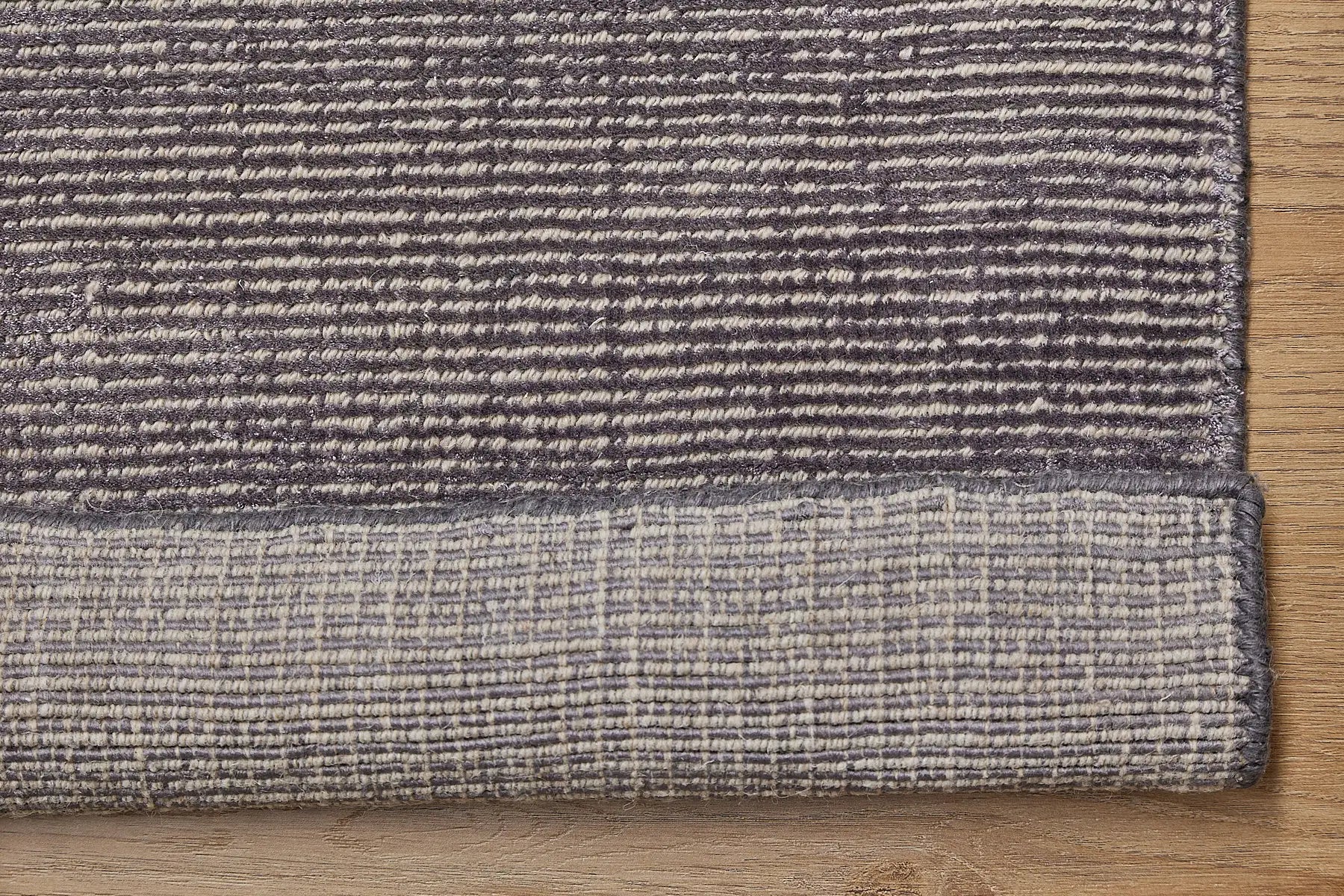 Pearl Garnet is a luxurious hand-loomed knotted rug made with wool and silky viscose. It boasts a ribbed texture and pile height of 12-14mm. Colour Blueish Grey with Beige accents. Sizes 160 X 230, 200 X 290 and 240 X 340. Fold.