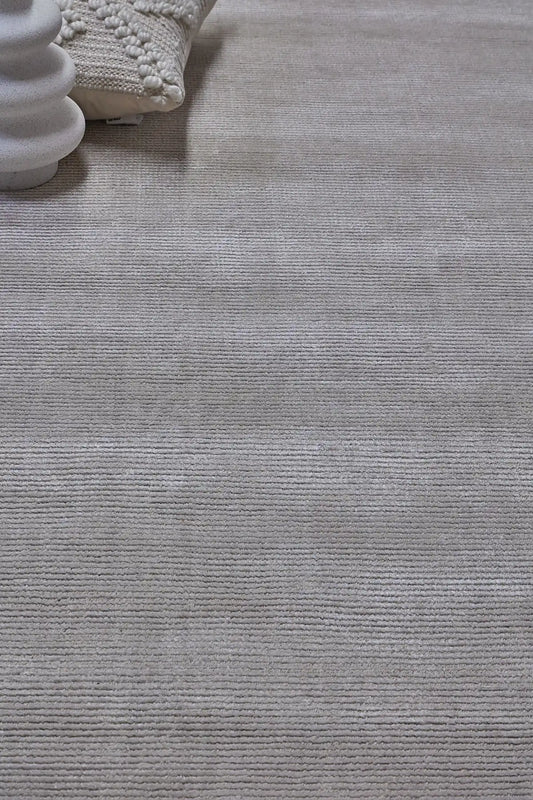 Pearl Grace is a luxurious hand-loomed knotted rug made with wool and silky viscose. It boasts a ribbed texture and pile height of 12-14mm. Colour Silver Grey. Sizes 160 X 230, 200 X 290 and 240 X 340. Life.