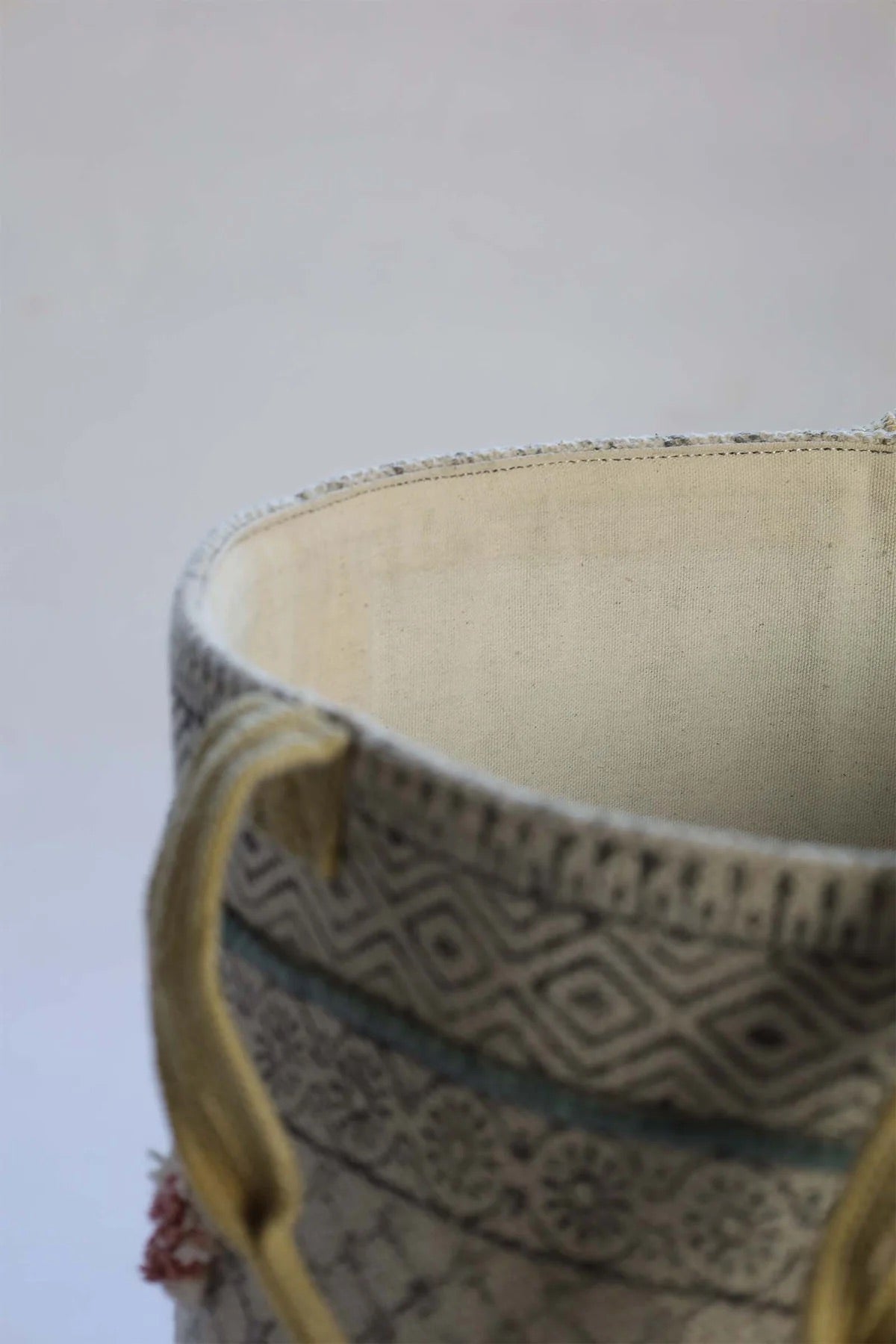 The Pearled Cotton Block Print Basket, boasts a bold motif block print design and 2 handles. Featuring an interior cotton lining and an outer textured cotton cover.  Colours, creams, dark blues, yellows and browns. Size 400 height X 350 diameter. Top Corner.