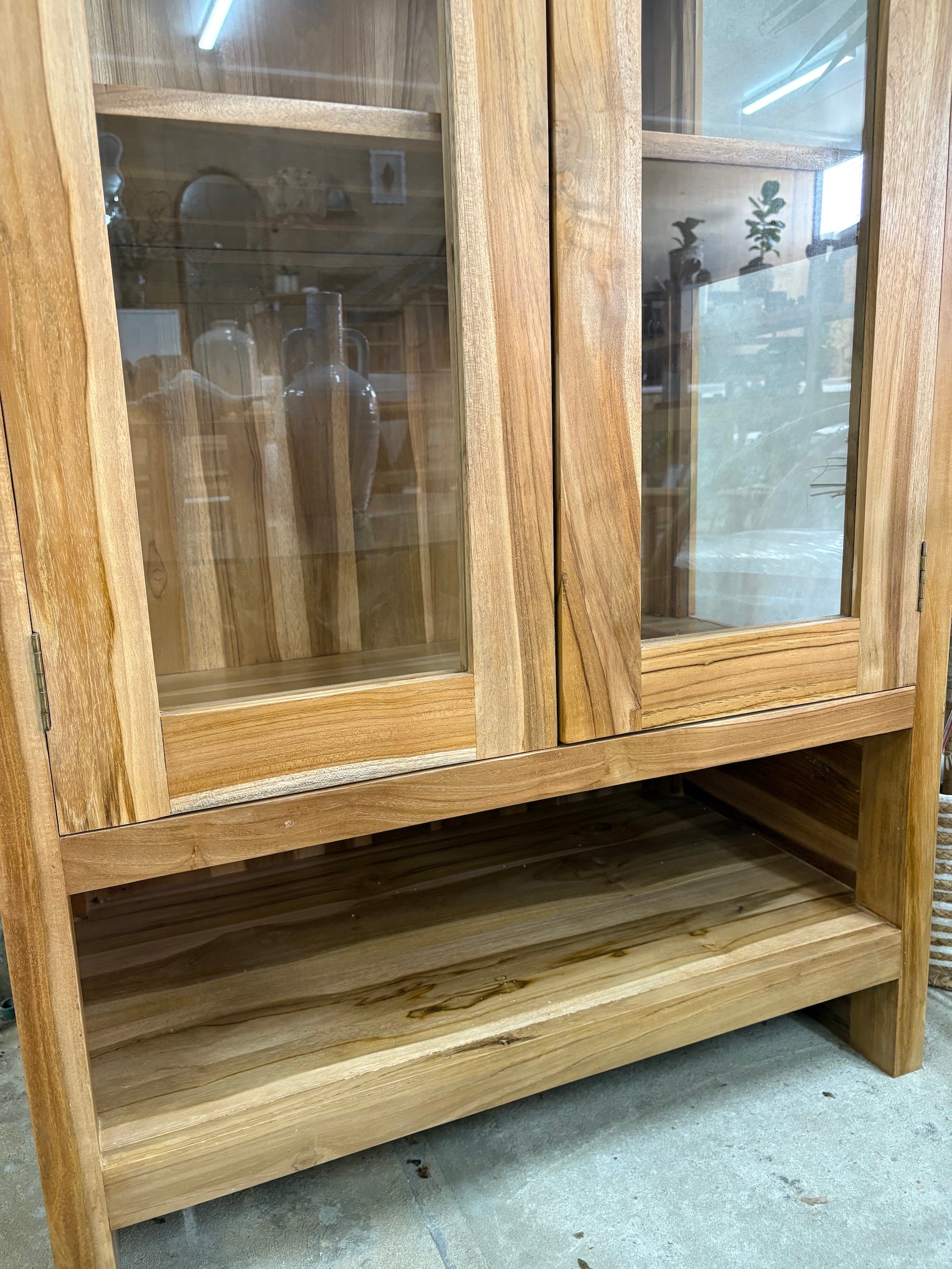 The Pisces Cabinet. Crafted from A grade teak featuring 2 glass doors and 1 lower shelf. Colour Natural. Measures 1700H x 450D x 800W. Bottom.