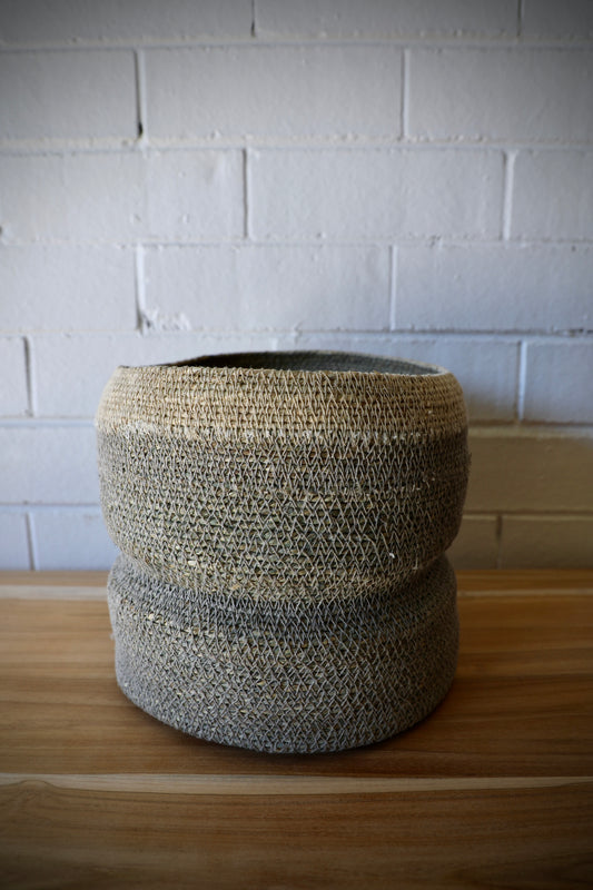 The Port Seagrass Basket - Small, is crafted from natural seagrass.  Its weave creates a rustic texture, perfect for storing most things. Colour Steel. Measures 22 Diameter X 22 Height. Side.