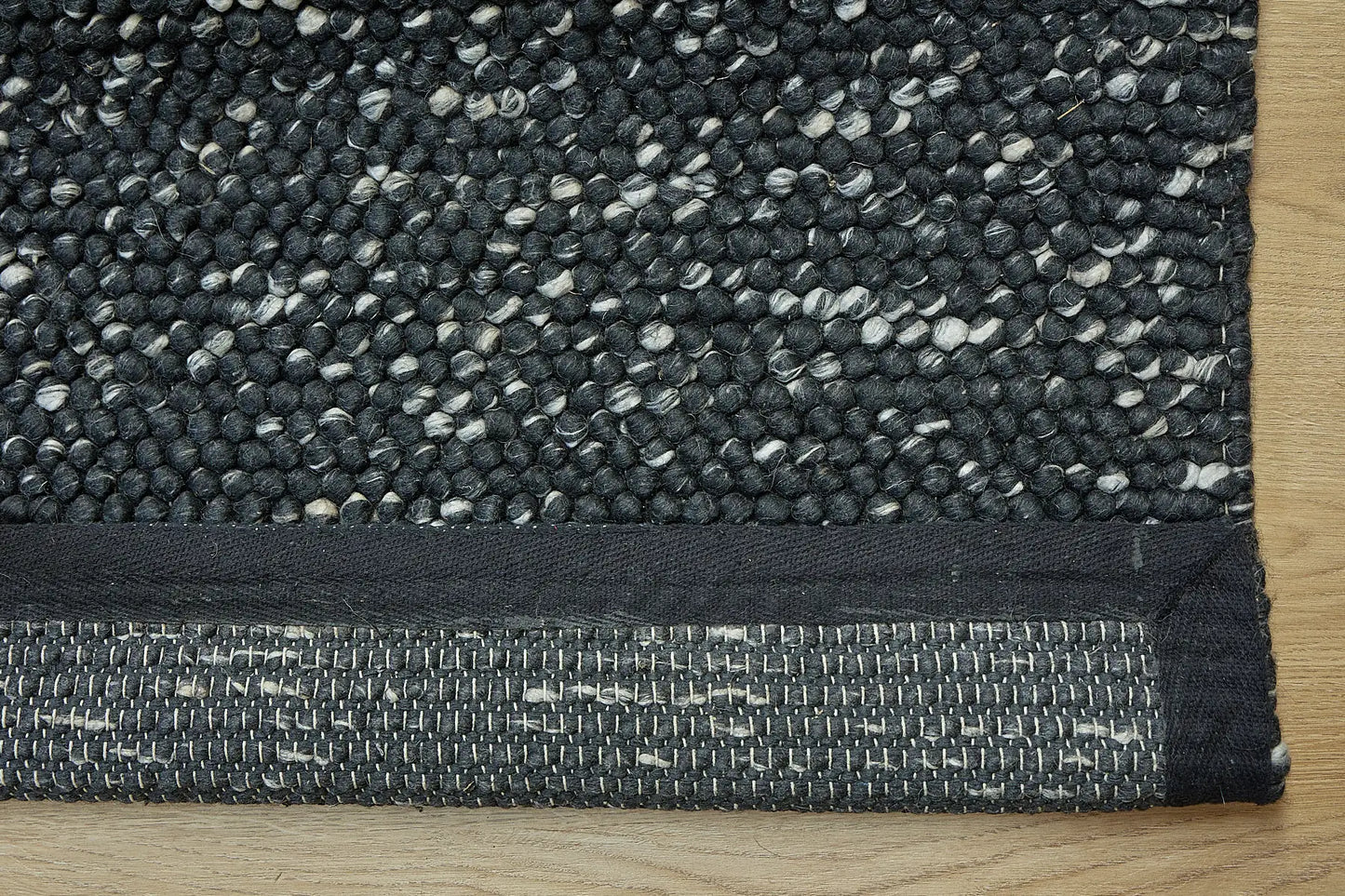 Rocks Black is a luxurious hand-woven wool carpet. Boasting a plush loop pile with 8-18mm pile height. Colour Black with white accents. Sizes 160 X 230, 200 X 290, 240 X 340 and 290 X 390. Fold.