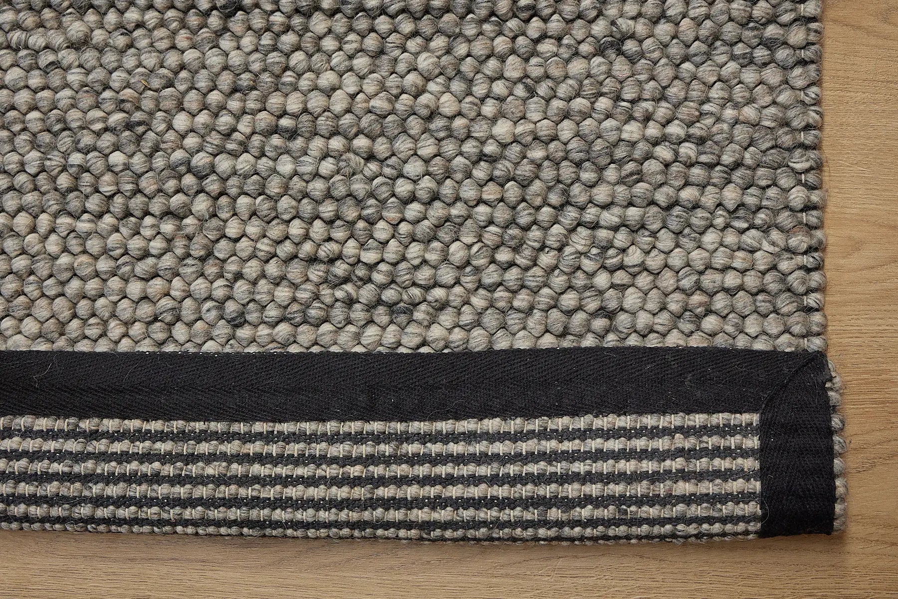 Rocks Grey is a luxurious hand-woven wool carpet. Boasting a plush loop pile with 8-18mm pile height. Colour Grey with Dark grey accents. Sizes 160 X 230, 200 X 290, 240 X 340 and 290 X 390. Fold.